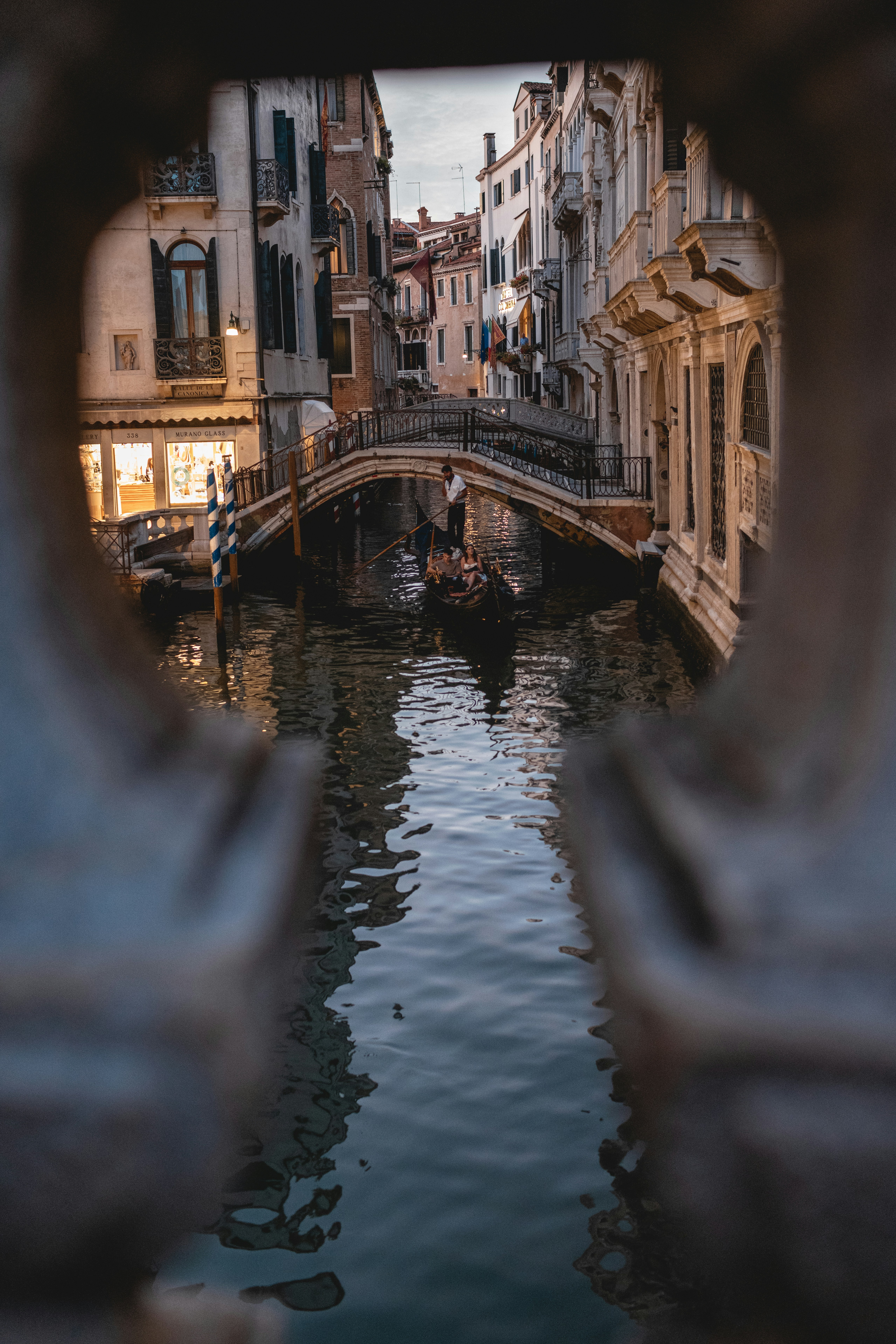 Gondola on a canal in venice with bridge.