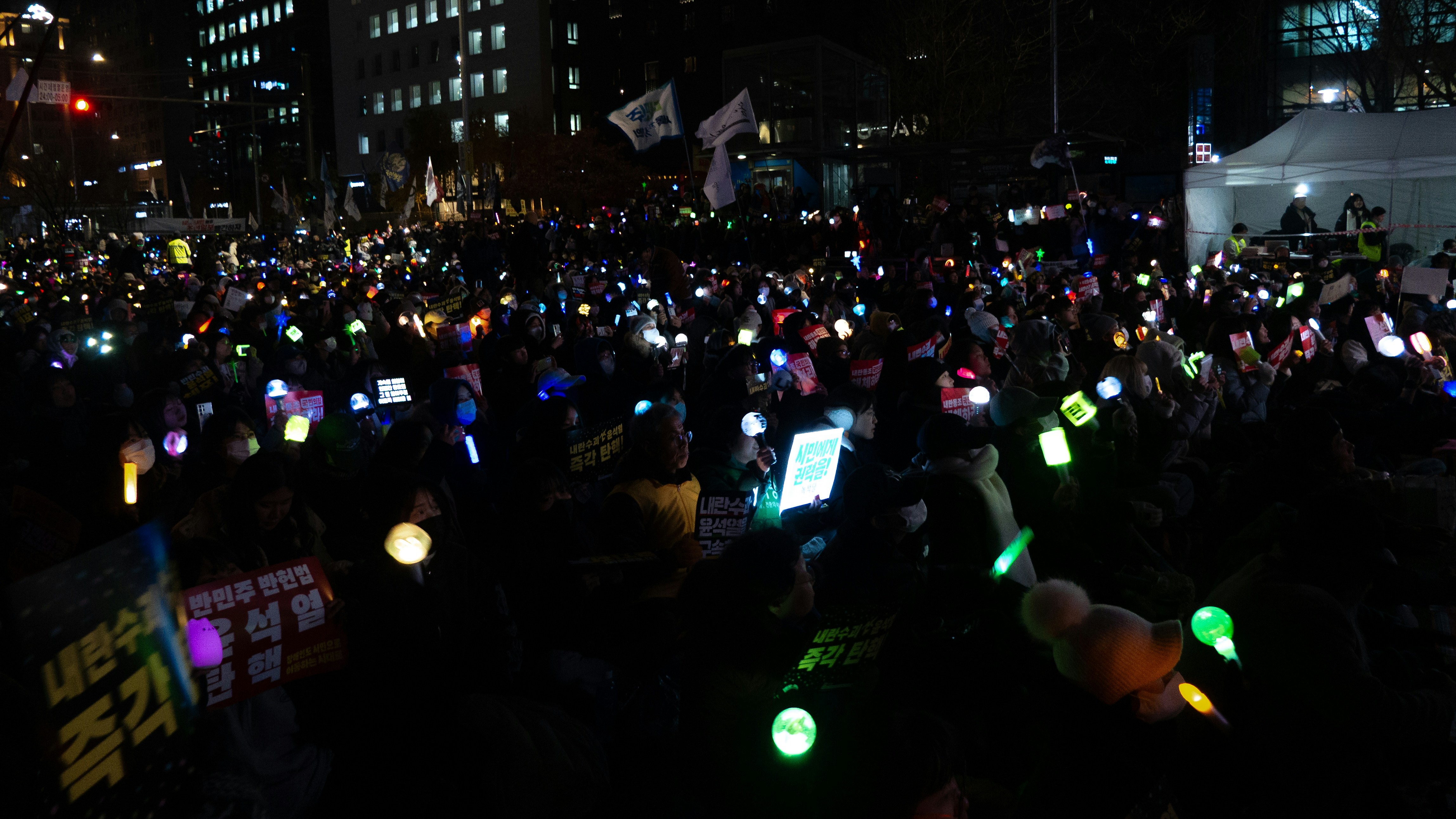 Crowd holding glowing lights at night demonstration