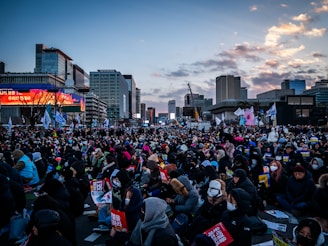 Crowd gathered in a city square at dusk