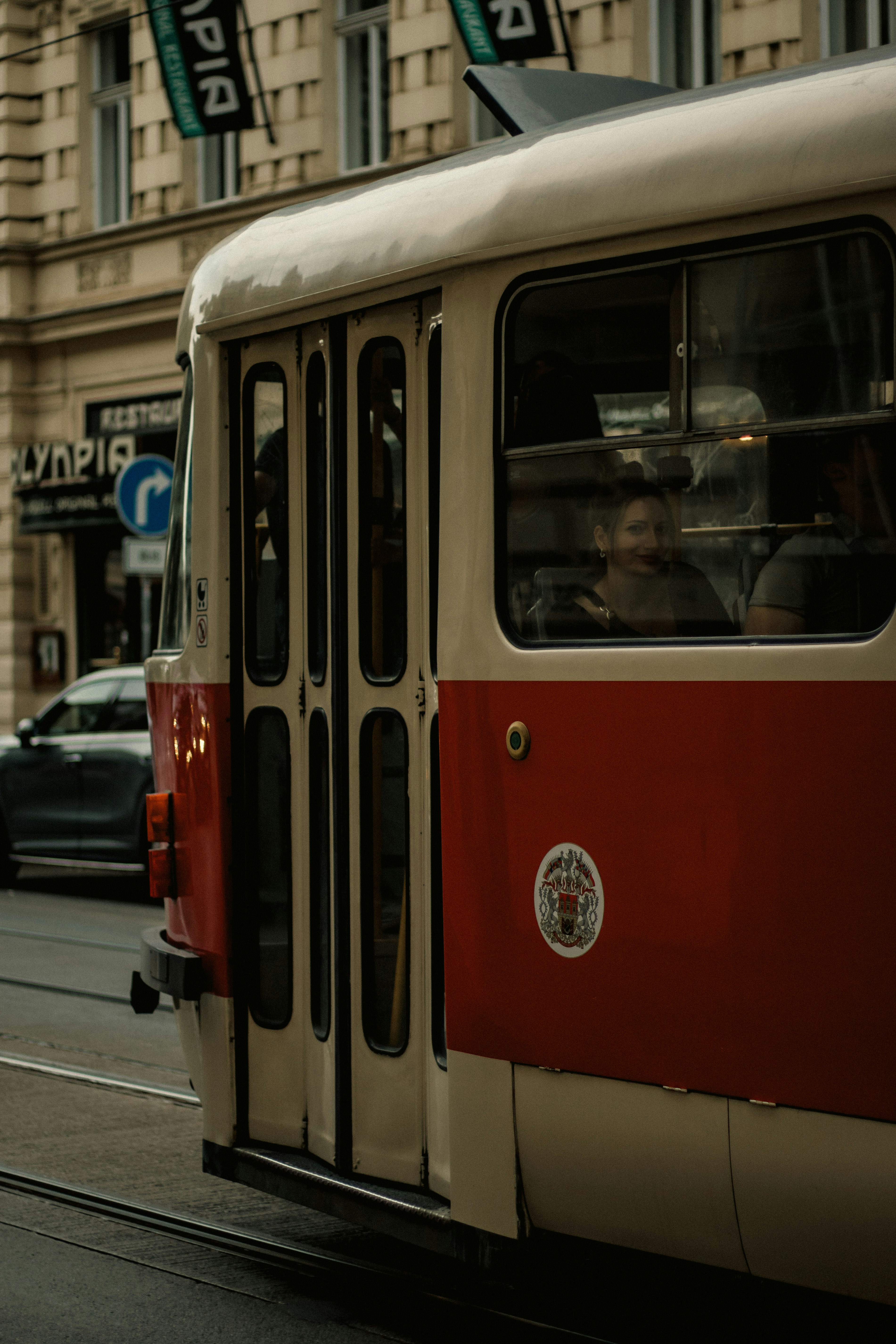 Red and white tram on city street