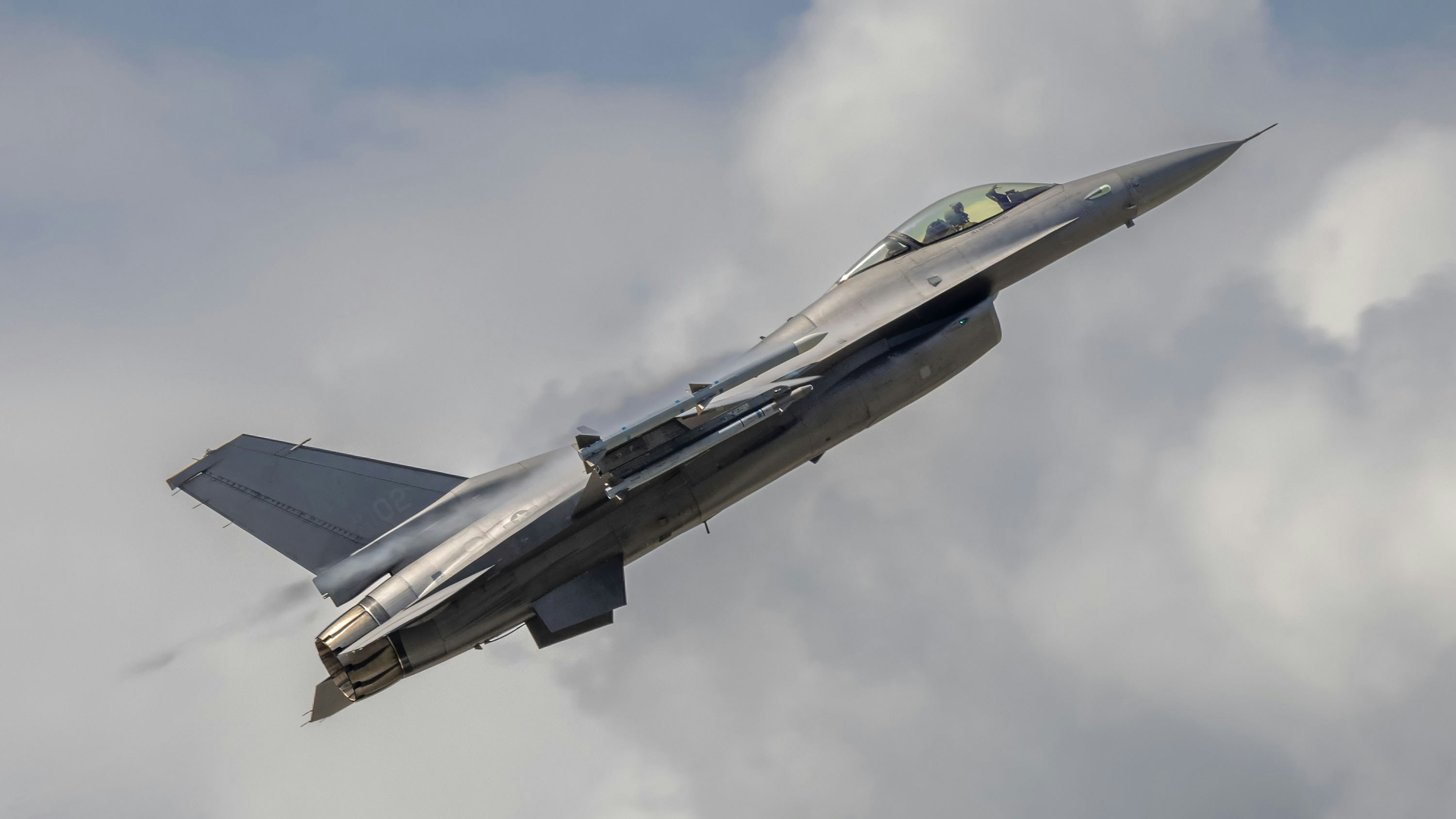 Ein Kampfjet, das sich scharf gegen einen bewölkten Himmel abhebt