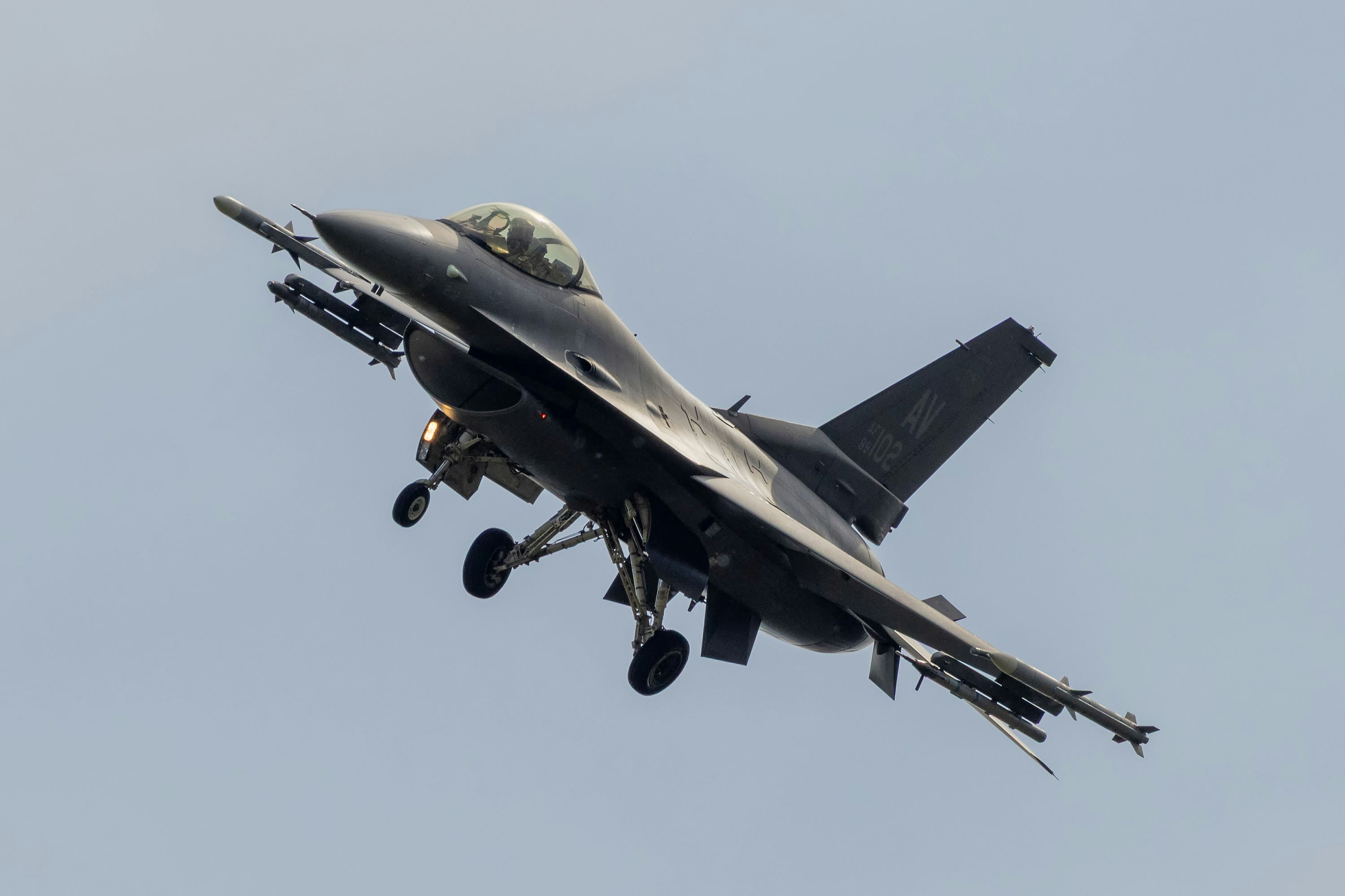 Ein dunkles Kampfflugzeug mit Raketen am Himmel