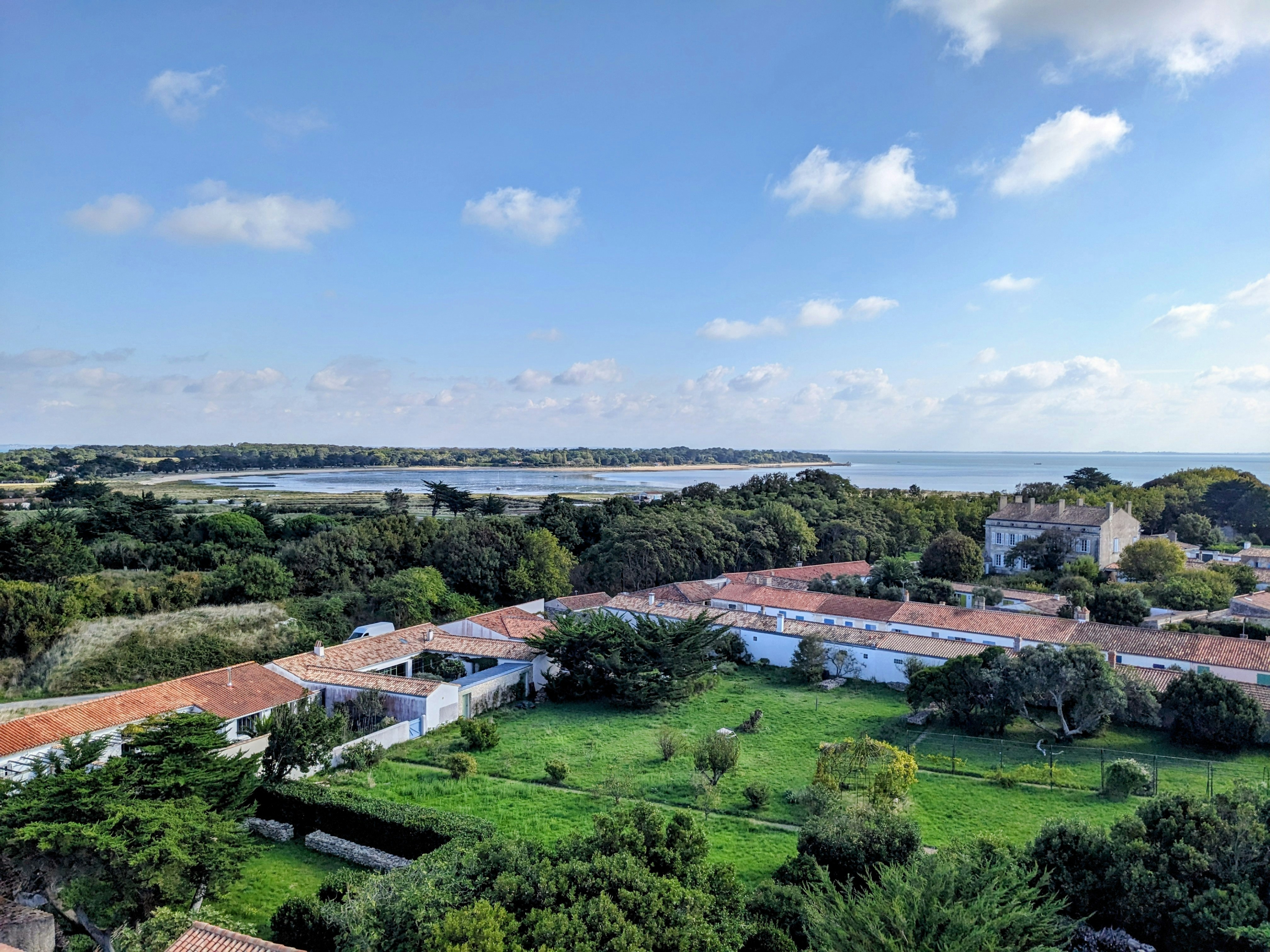 Ein Küstendorf, umgeben von üppigen grünen Bäumen.