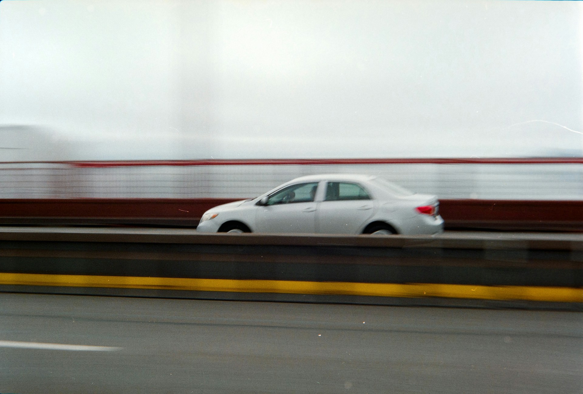 White car driving on a bridge