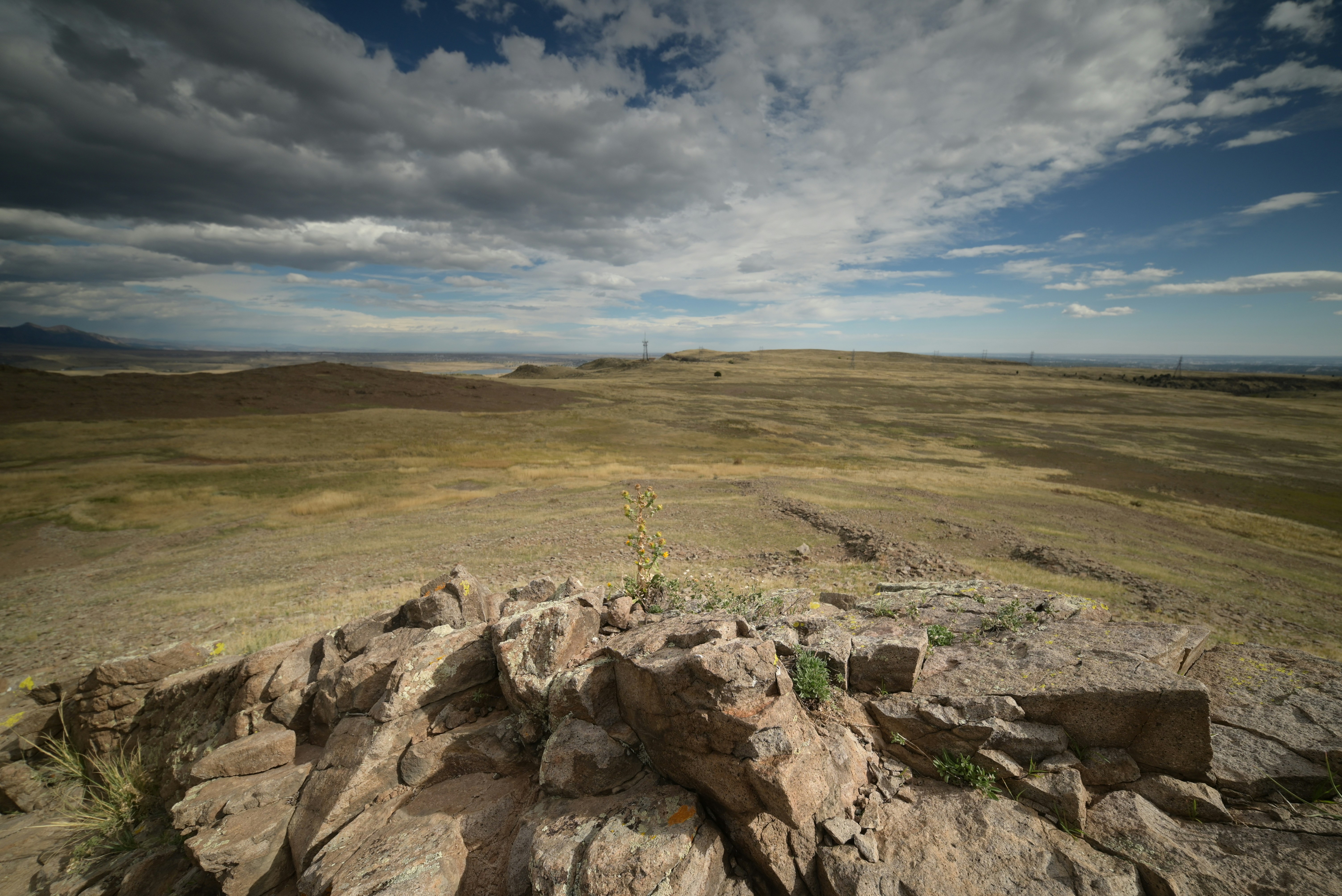 Rocky outcrop overlooking a vast, dry landscape under clouds