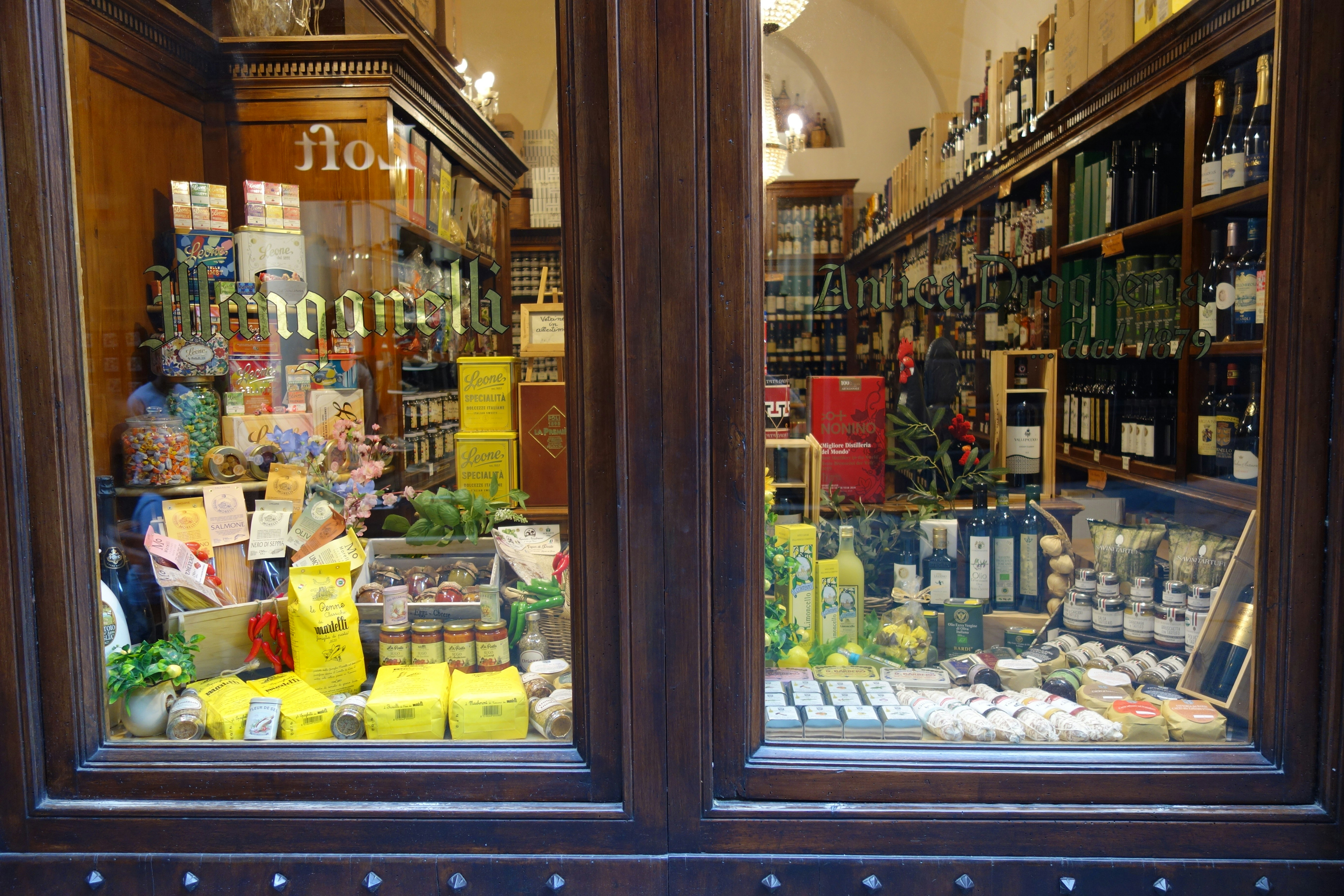 Window display of a well-stocked deli or specialty food store.