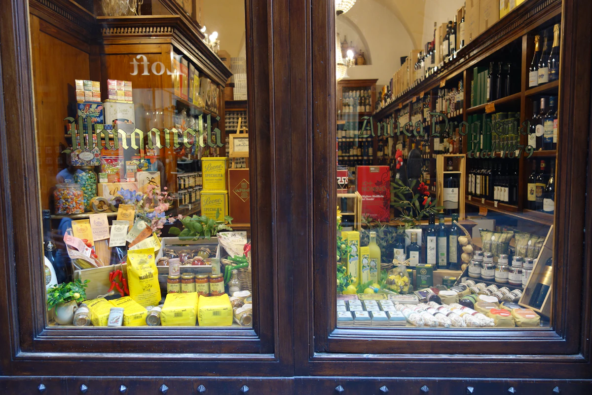 Vitrine d'une épicerie fine garnie de bocaux, de conserves et de produits secs