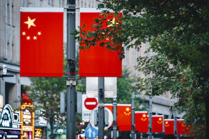 Chinese flags displayed on a street with trees