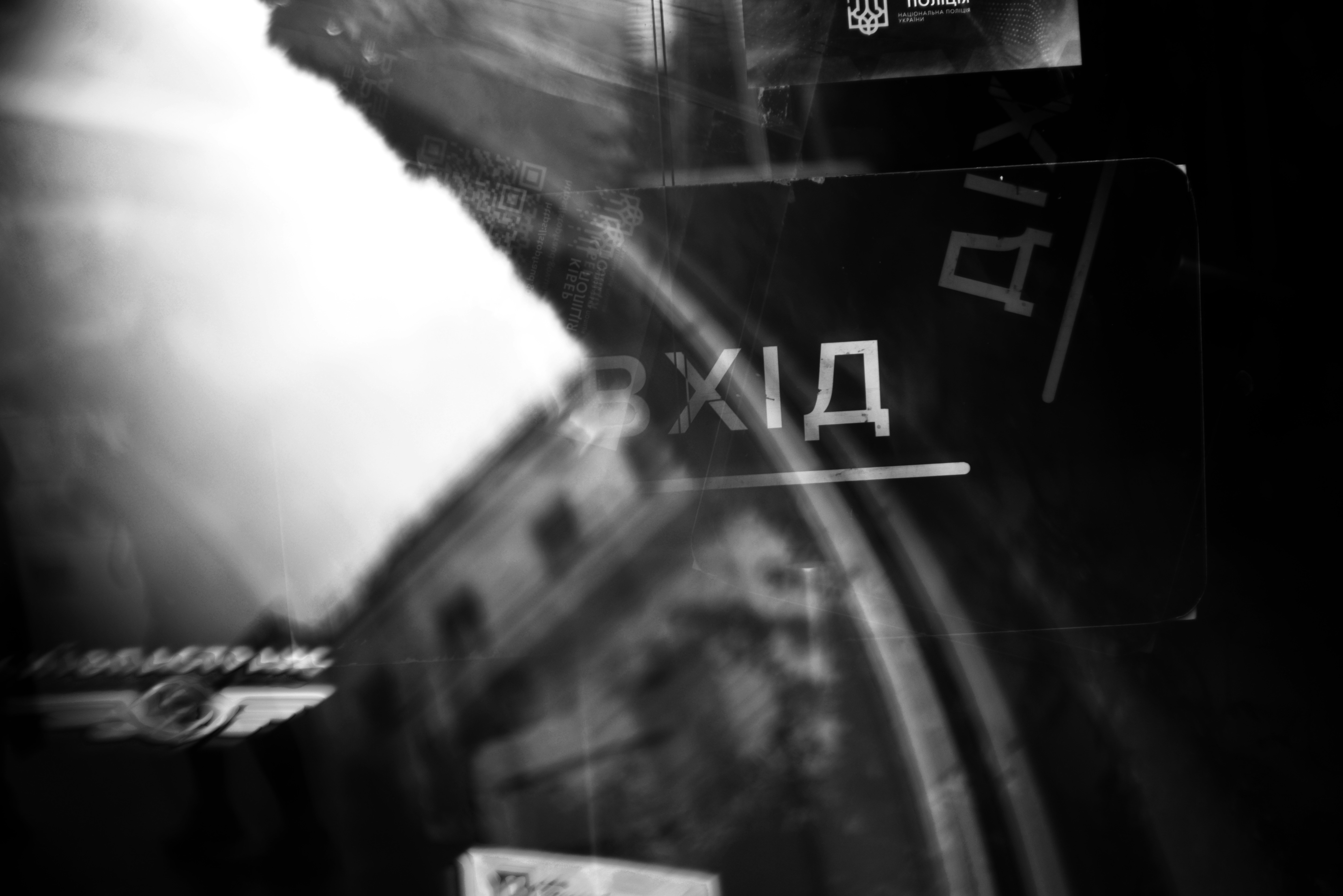 Verschwommene schwarz-weiße Stadtszene mit Schildern.