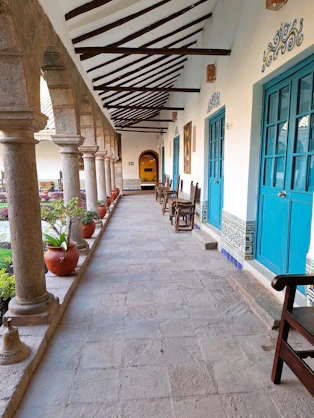 Courtyard walkway with stone columns and blue doors.