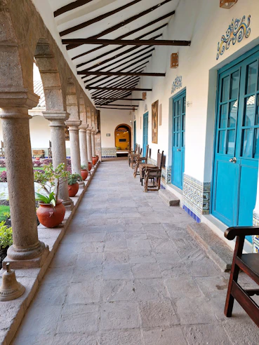 Courtyard walkway with stone columns and blue doors.