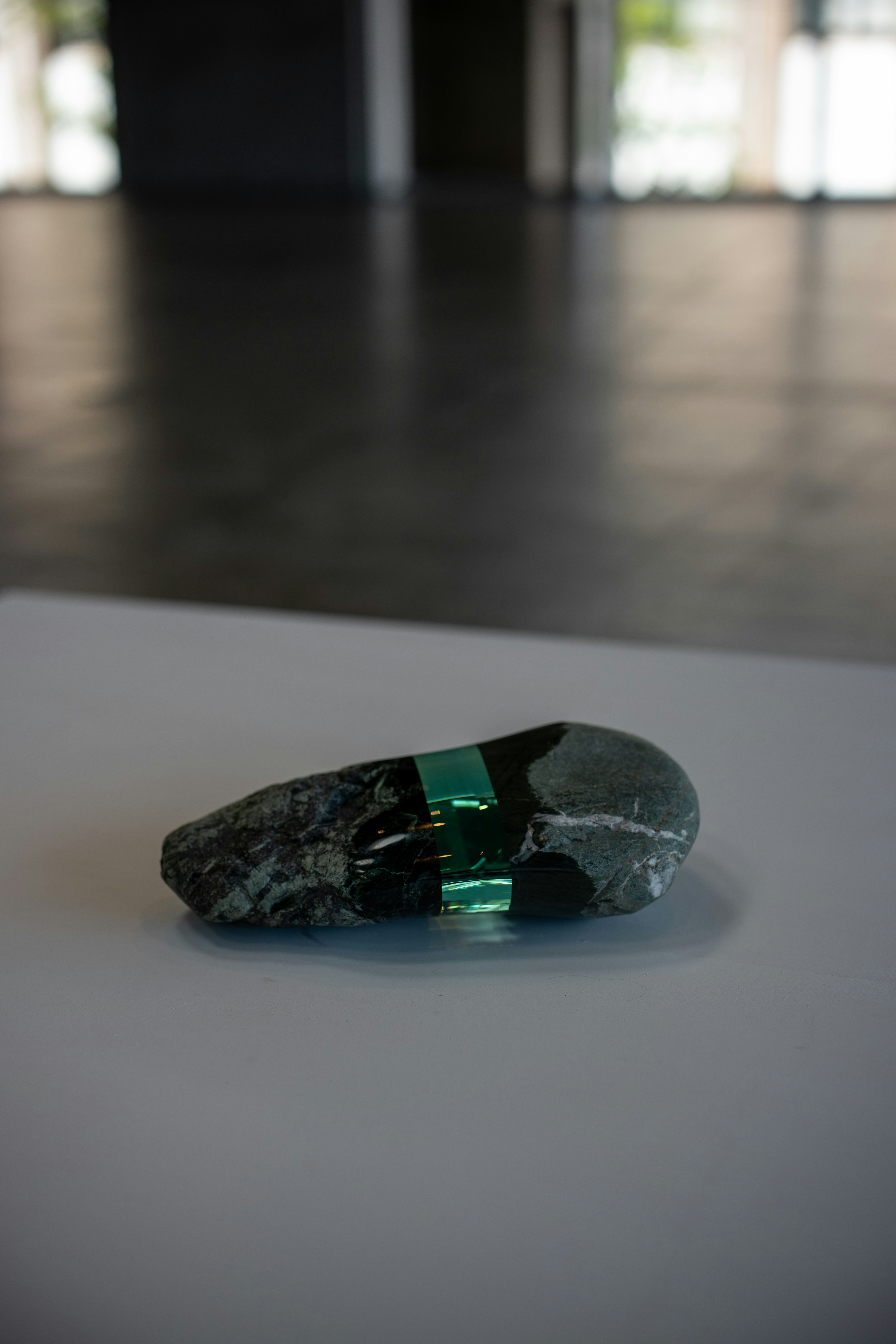 Pierre avec verre vert incrusté sur surface blanche