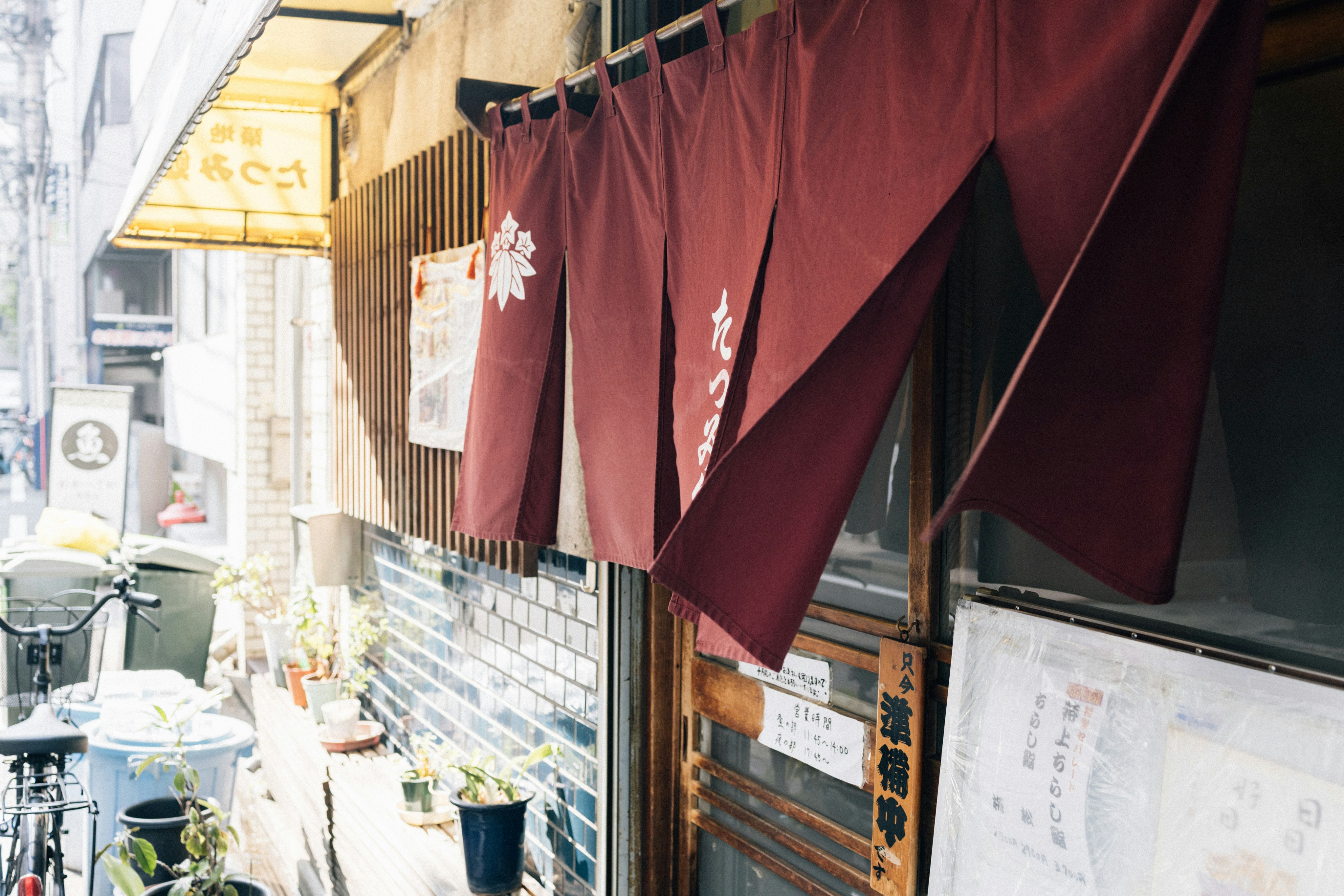 Cortinas rojas noren cuelgan afuera de la entrada de un restaurante japonés.