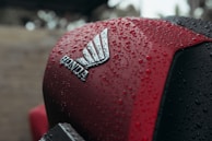Red motorcycle with honda logo covered in water droplets