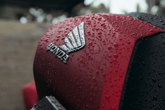 Red motorcycle with honda logo covered in water droplets