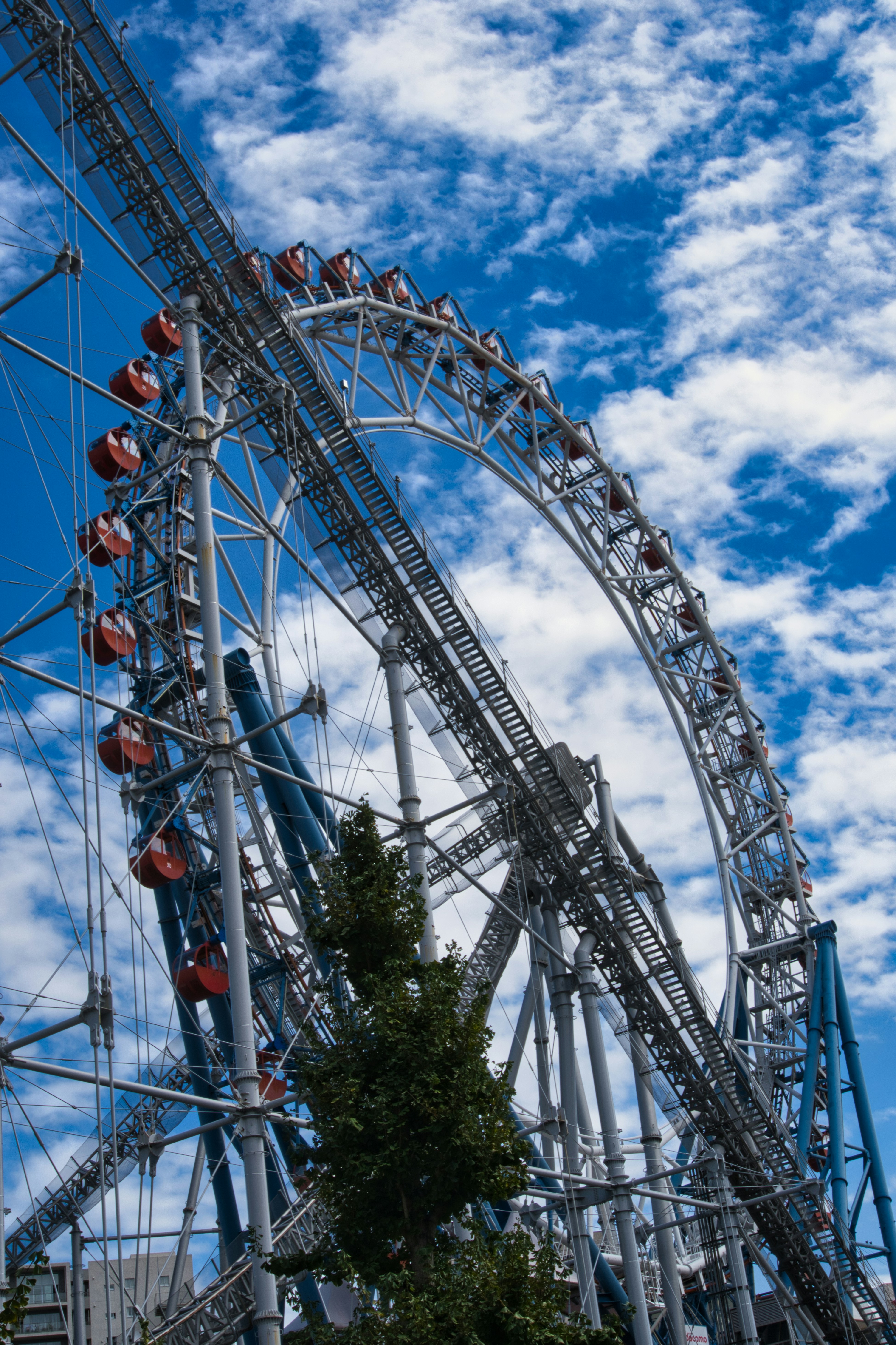 Riesenrad vor wolkenverhangenem blauem Himmel