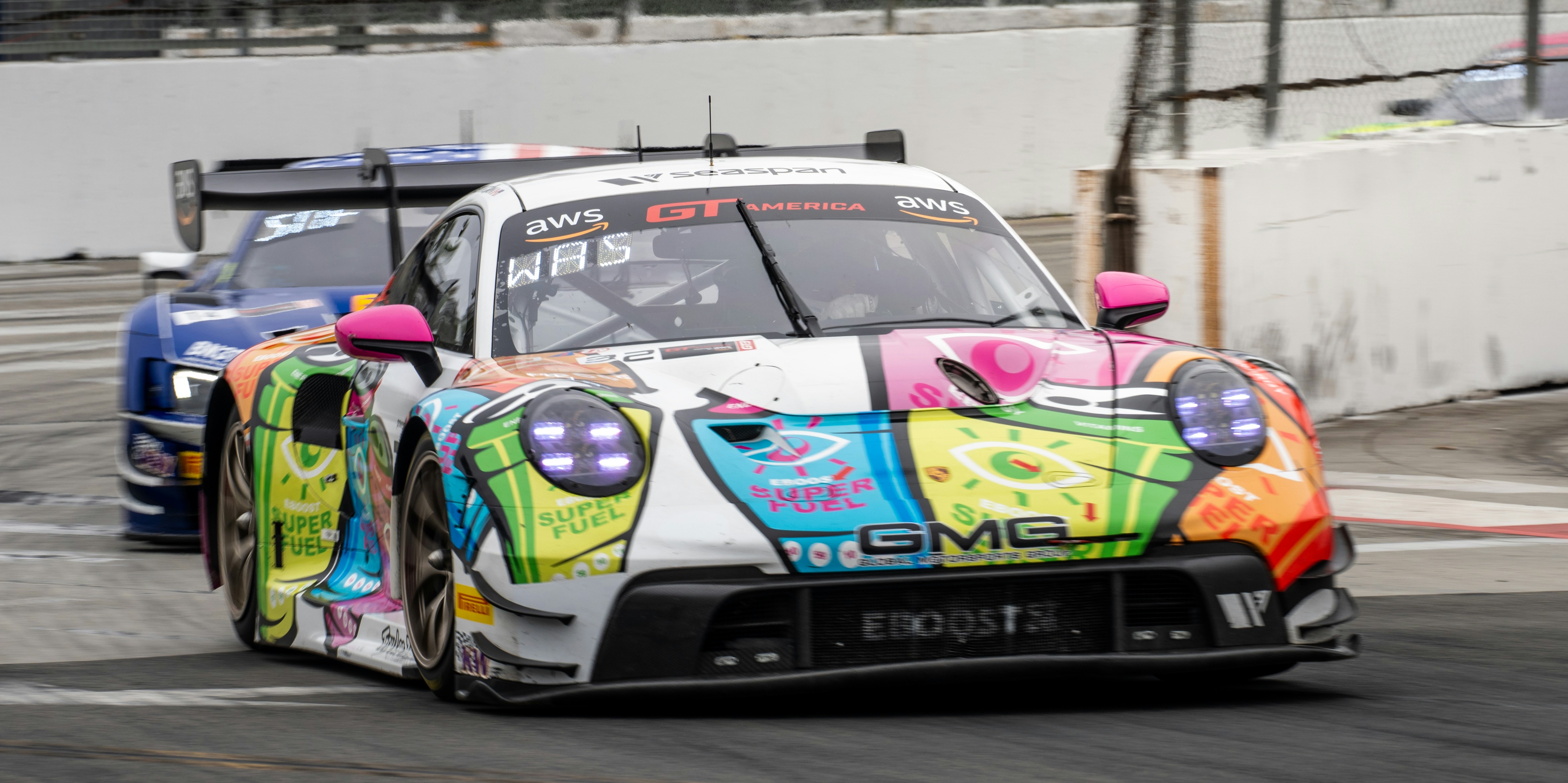 Colorful porsche race car speeding on track.