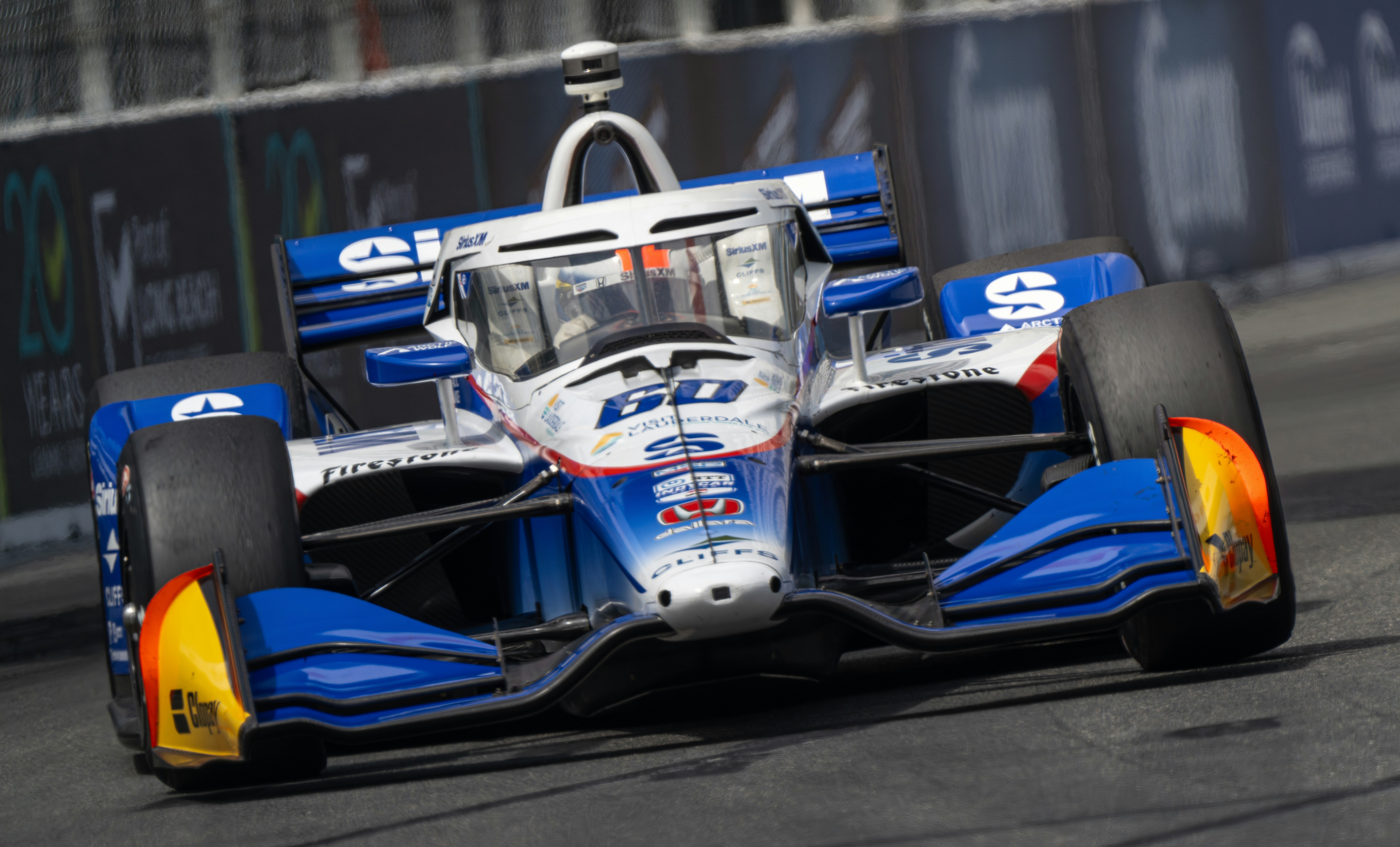 Blue and white race car speeding on track.