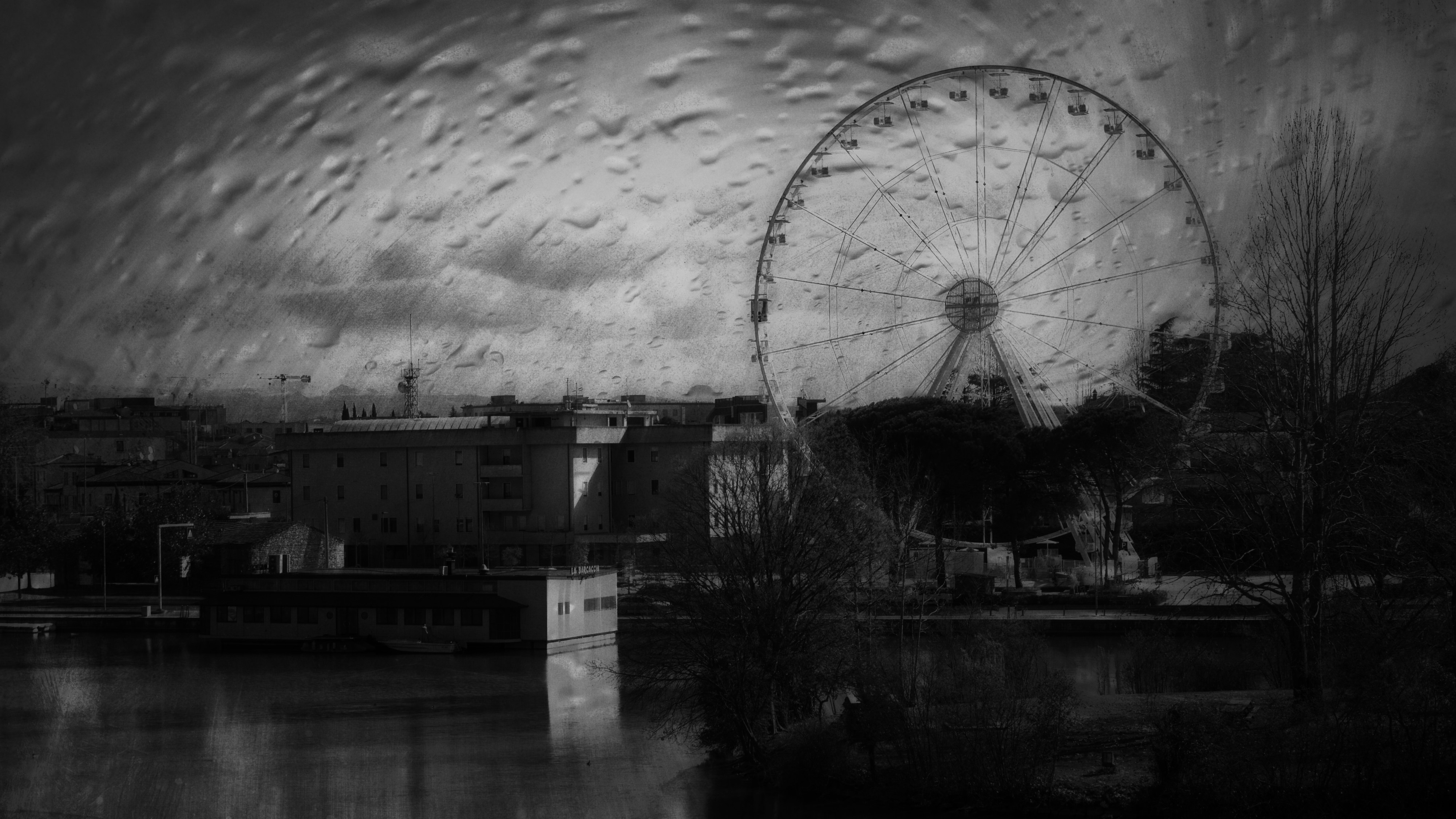 Ferris wheel overlooking a city skyline at dusk.