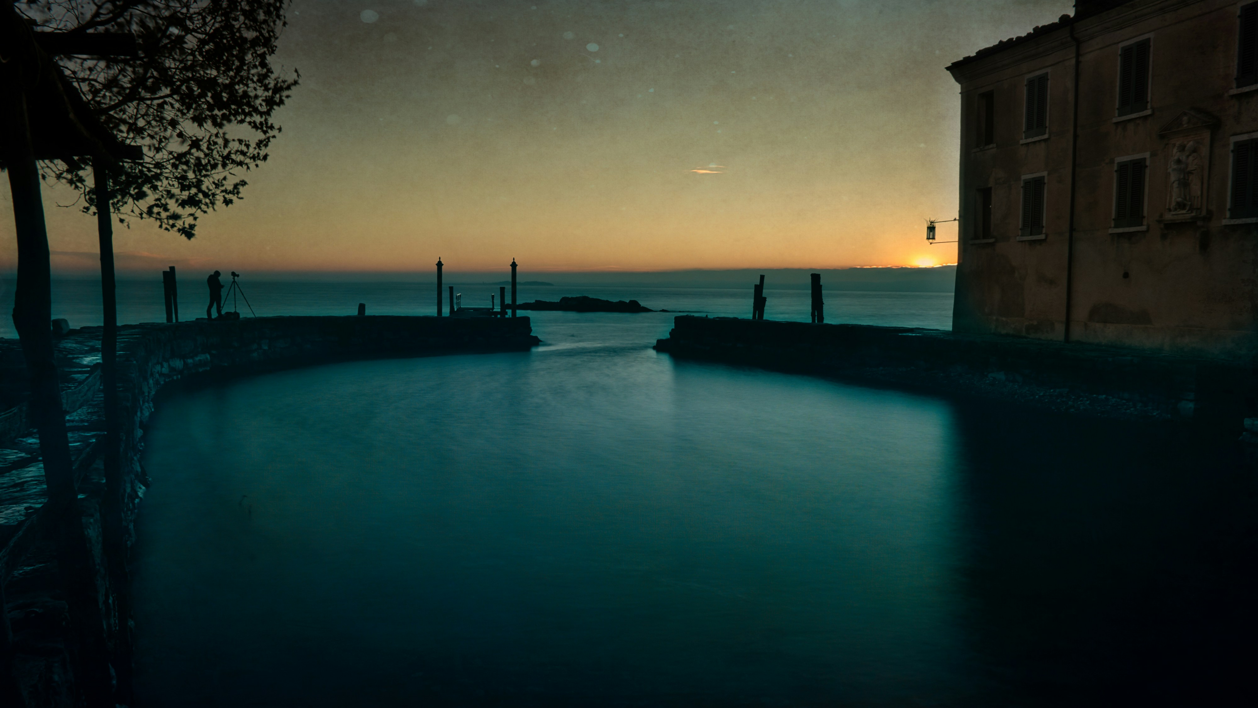 Calm canal at sunset with building and stars