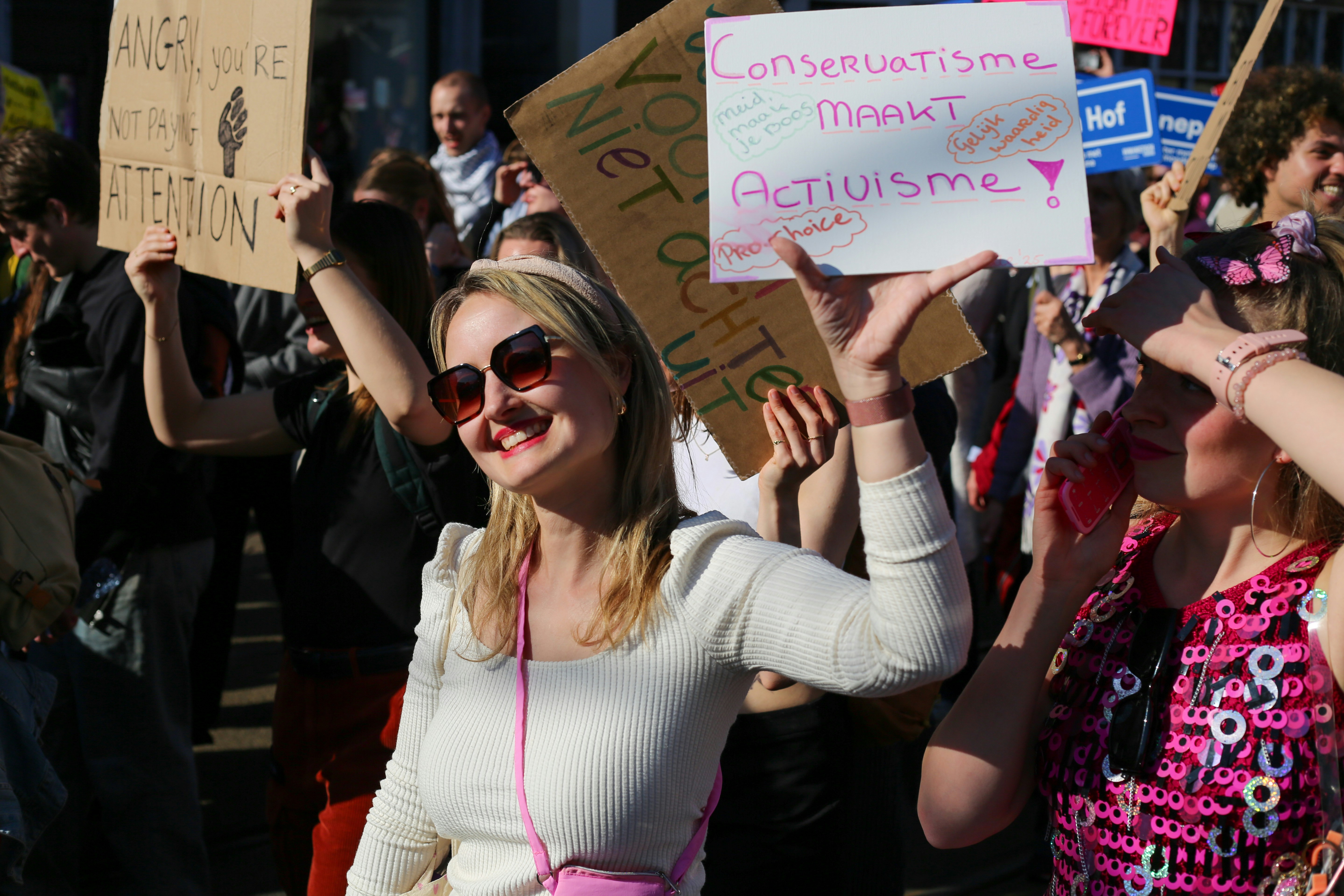 Mujer sosteniendo un cartel de protesta con texto sobre activismo
