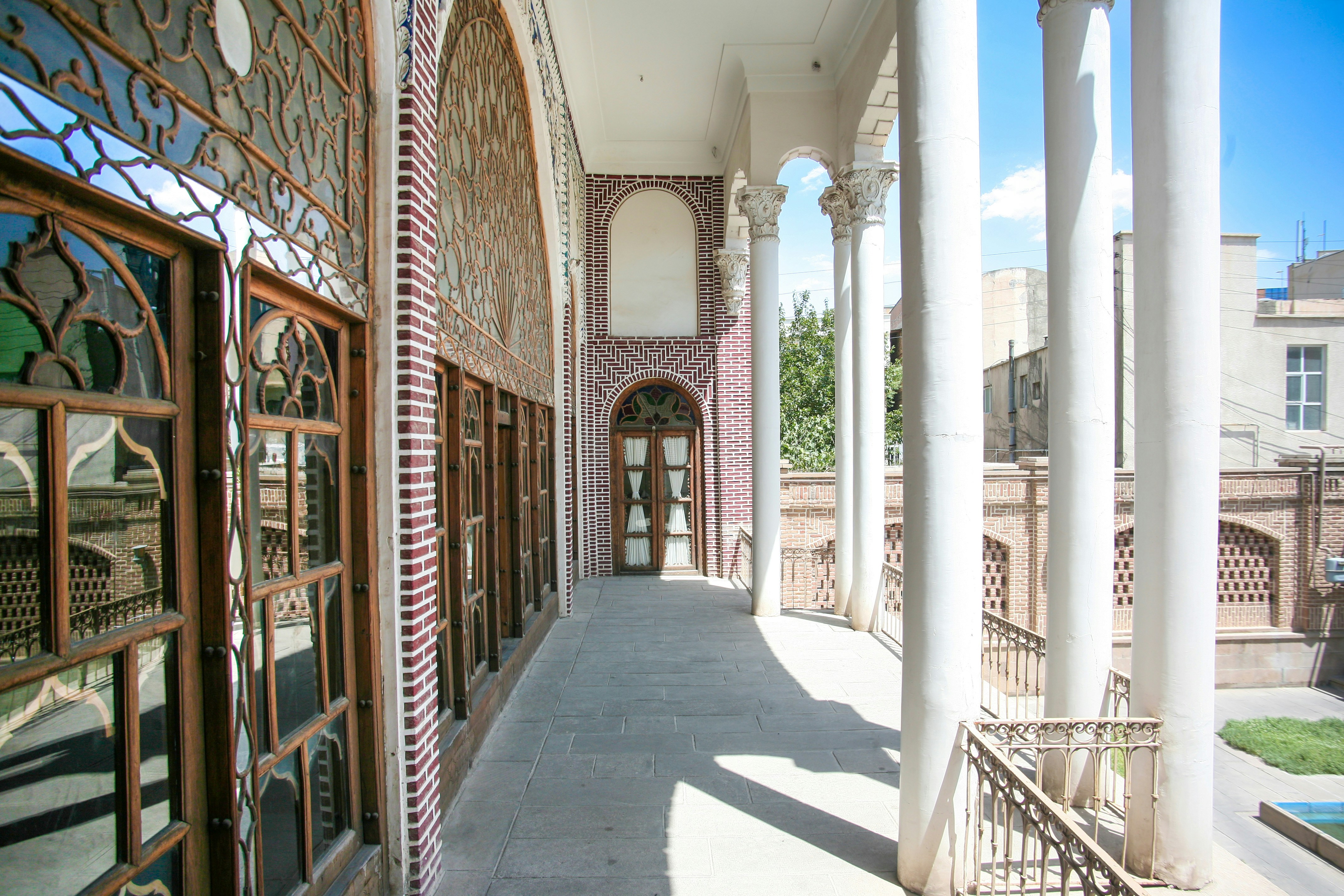 Ornate colonnade of a traditional building with patterned windows.