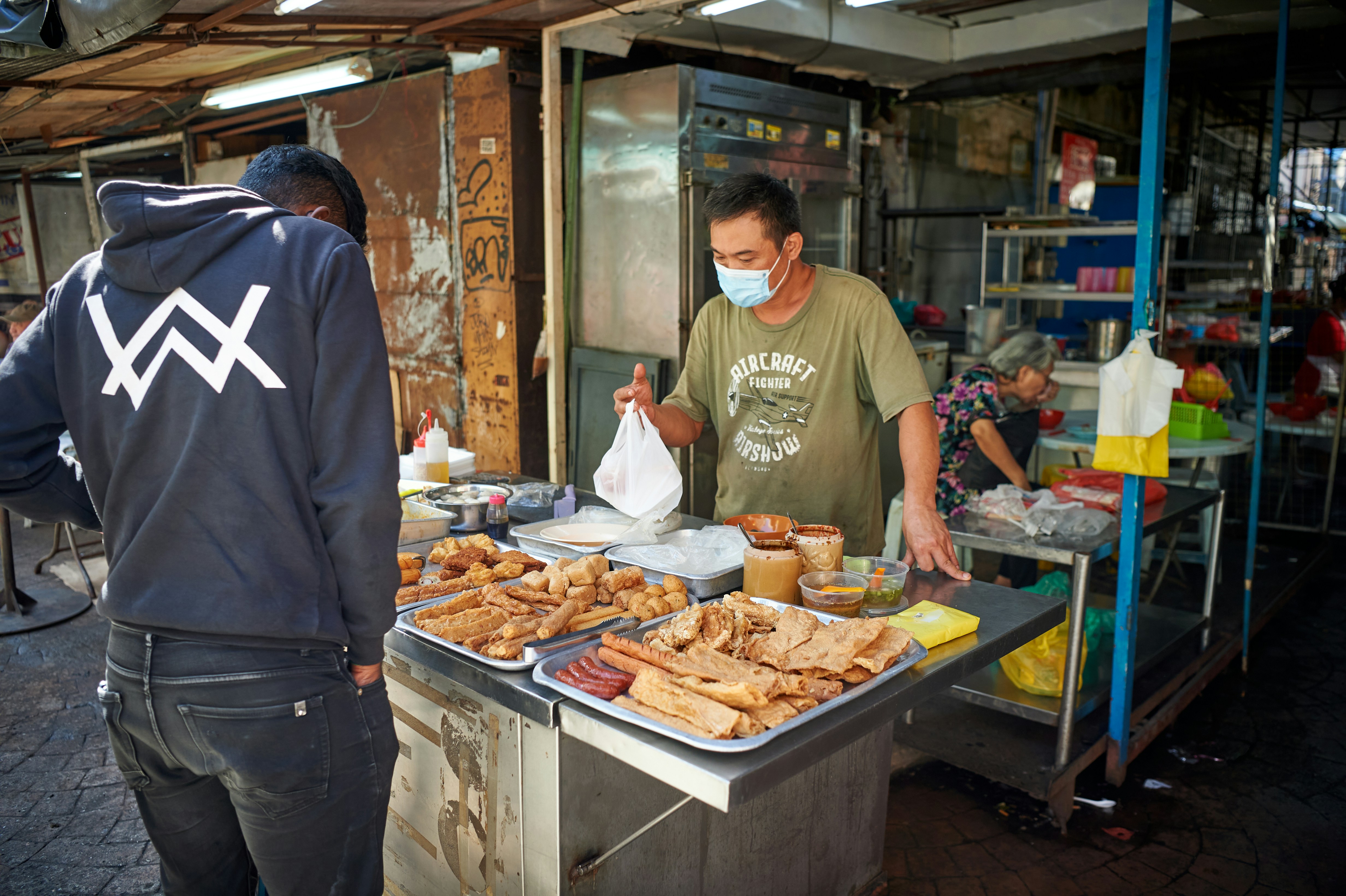 Vendor serving food at a market stall.