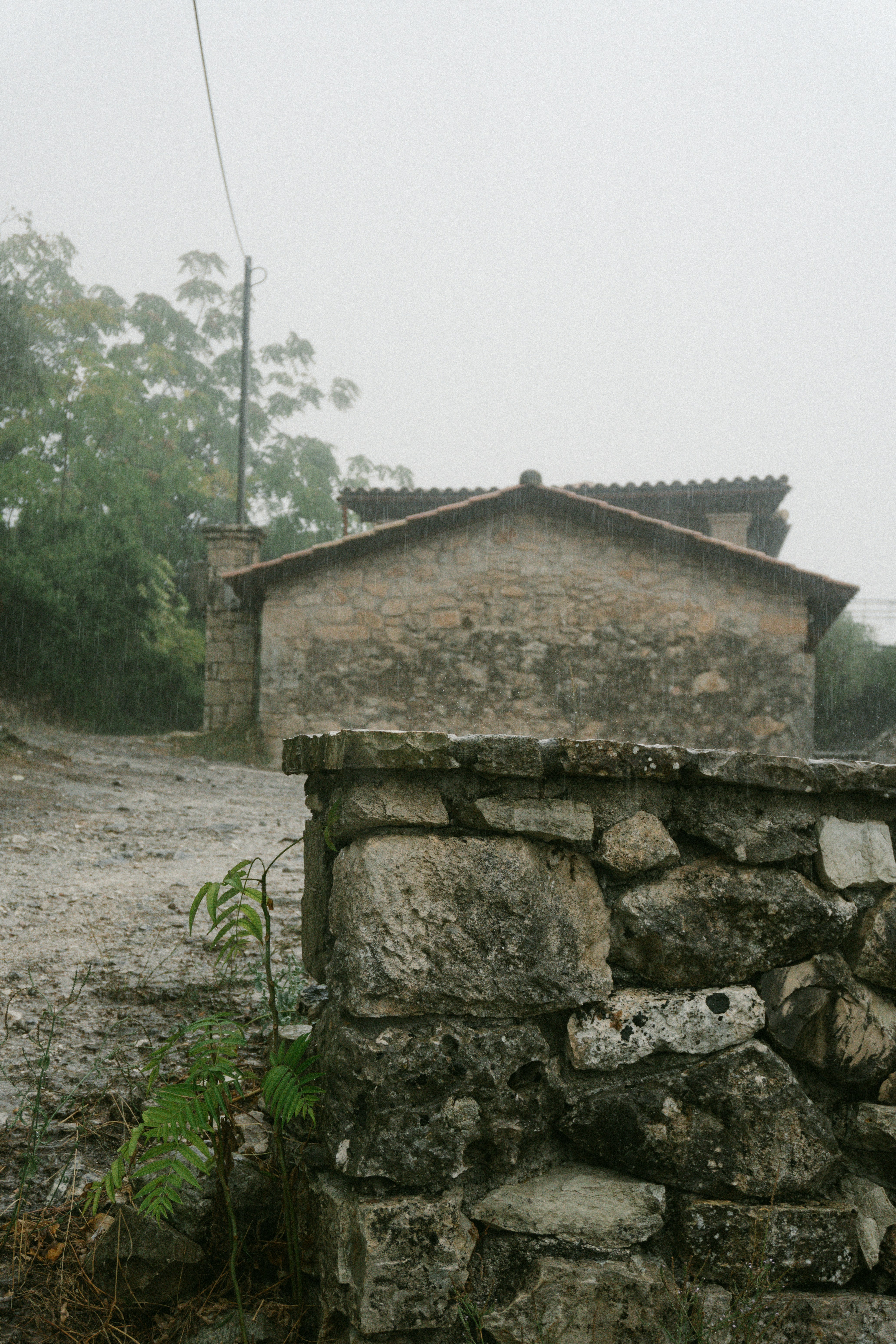 Stone wall and building in the rain