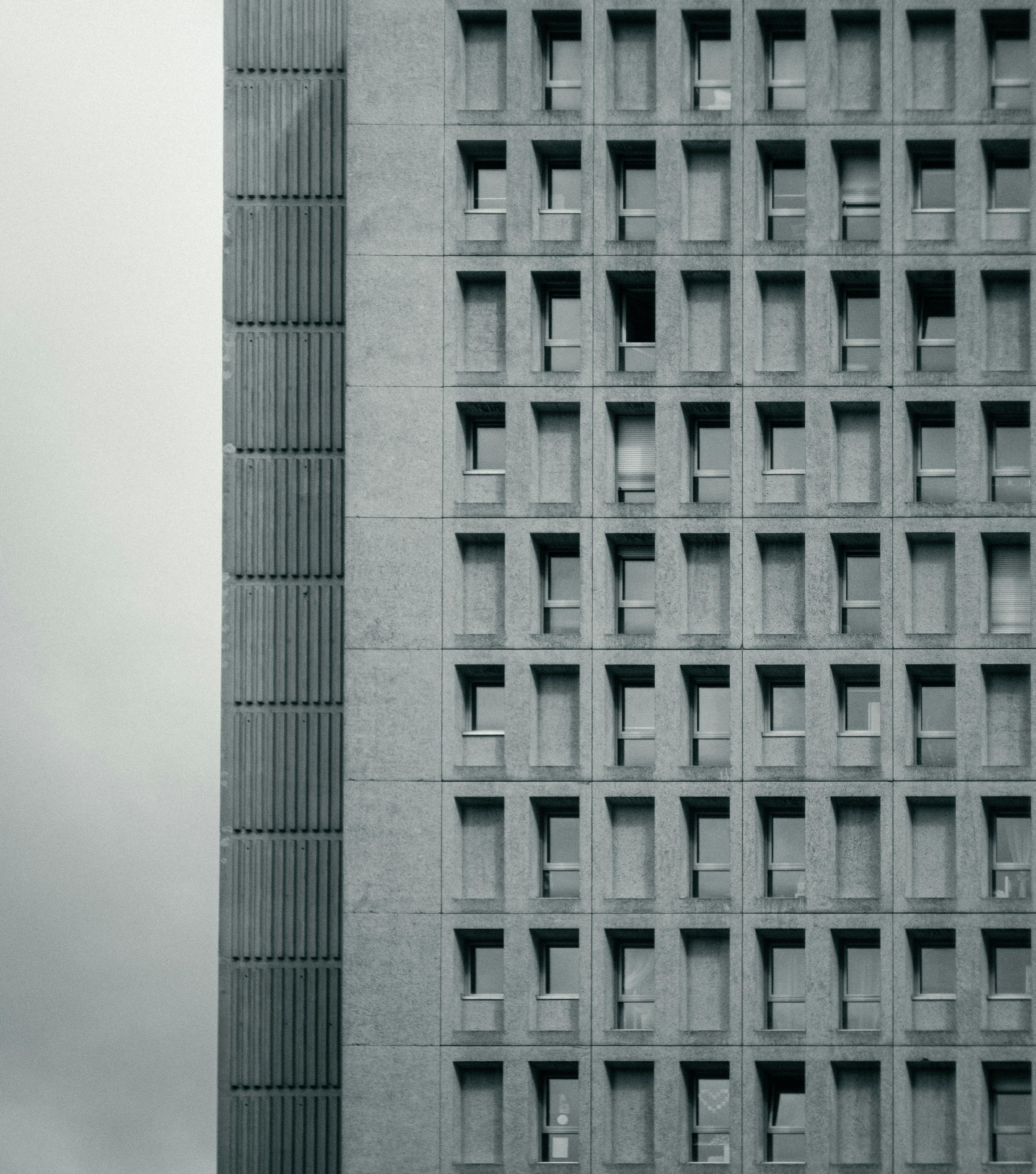 Concrete building facade with repetitive window patterns