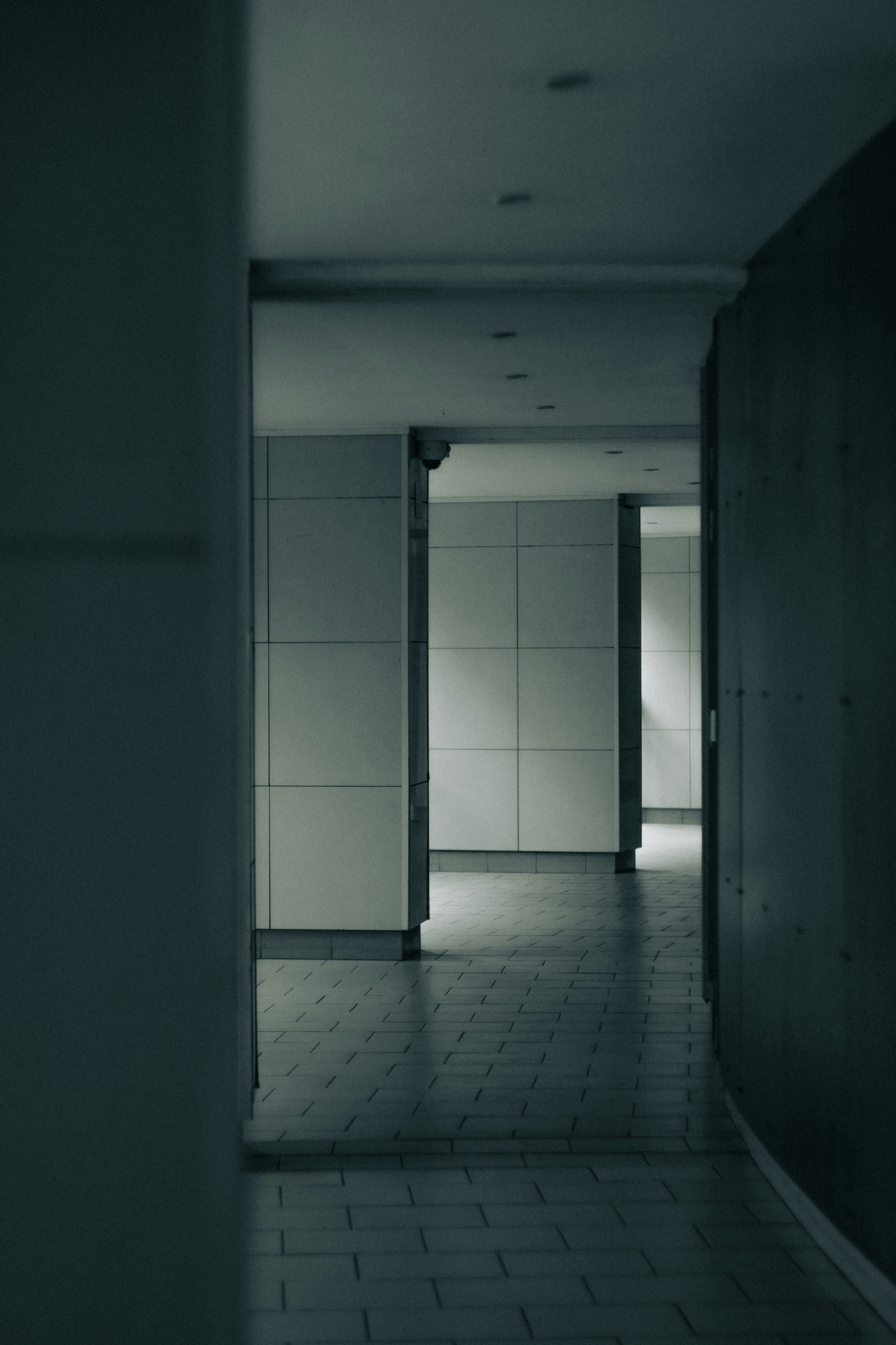 Dark hallway with tiled walls and floor.
