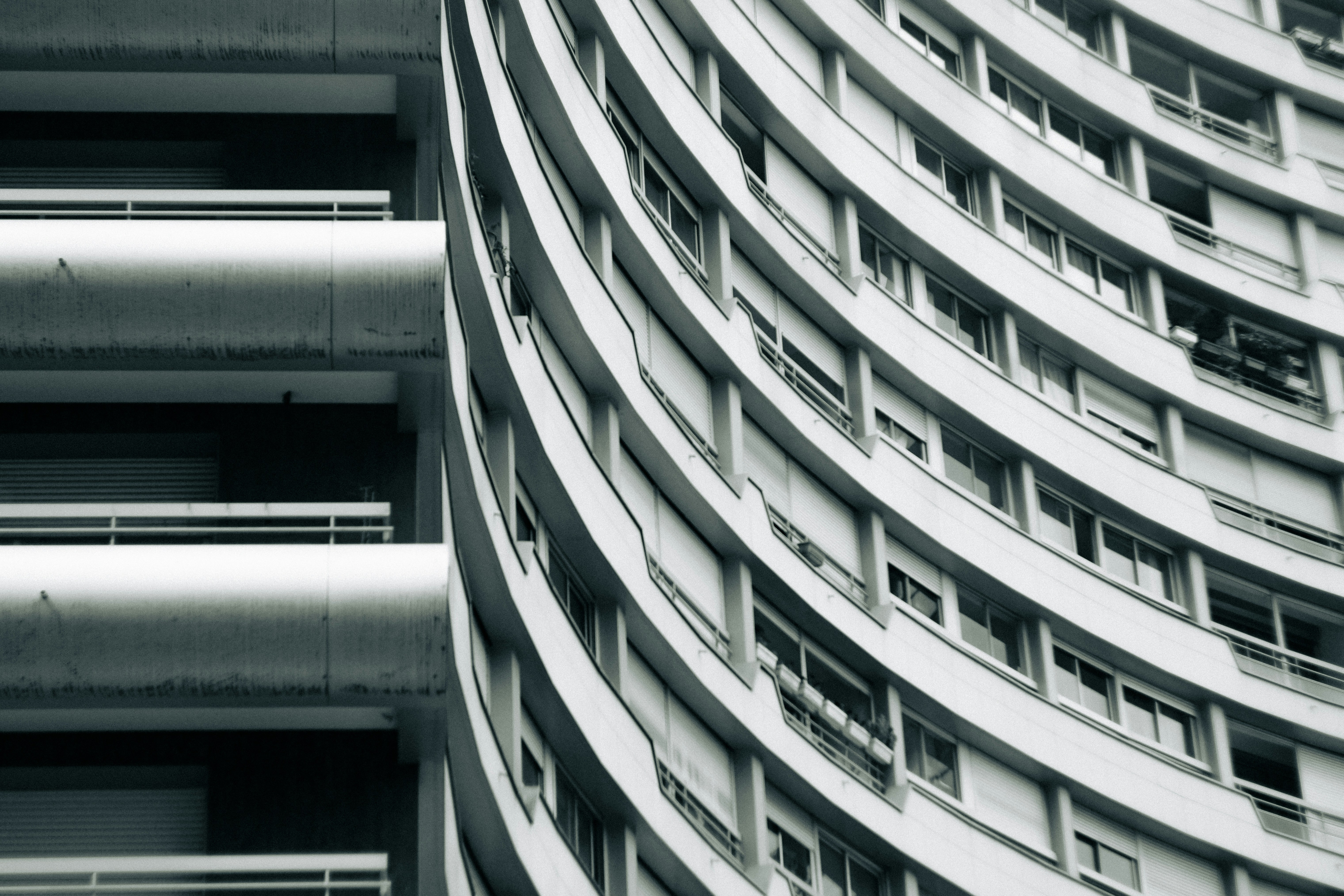 Curved modern building facade with many windows.