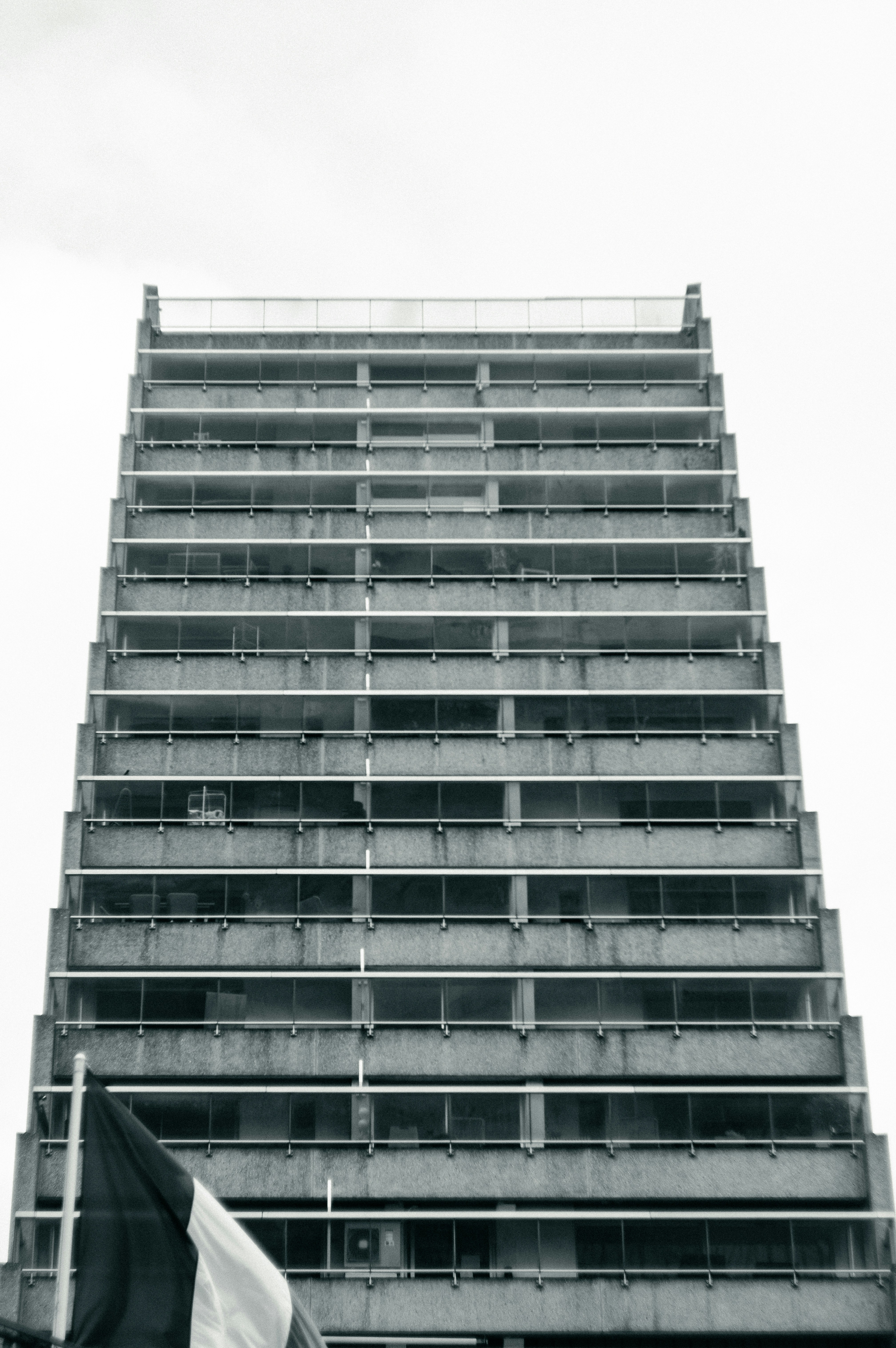 Tall concrete building with balconies against a bright sky
