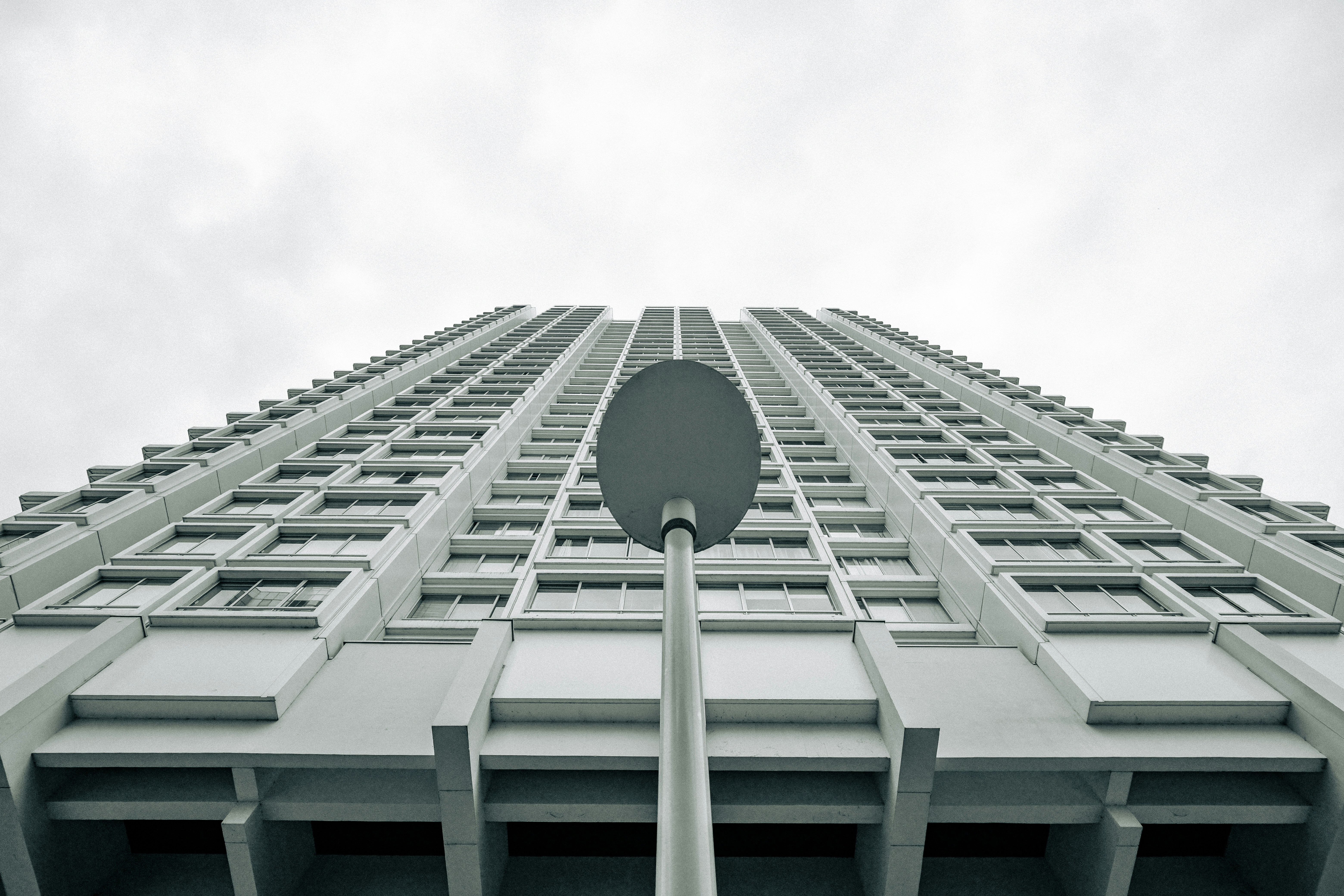 Looking up at a tall building with a street lamp.