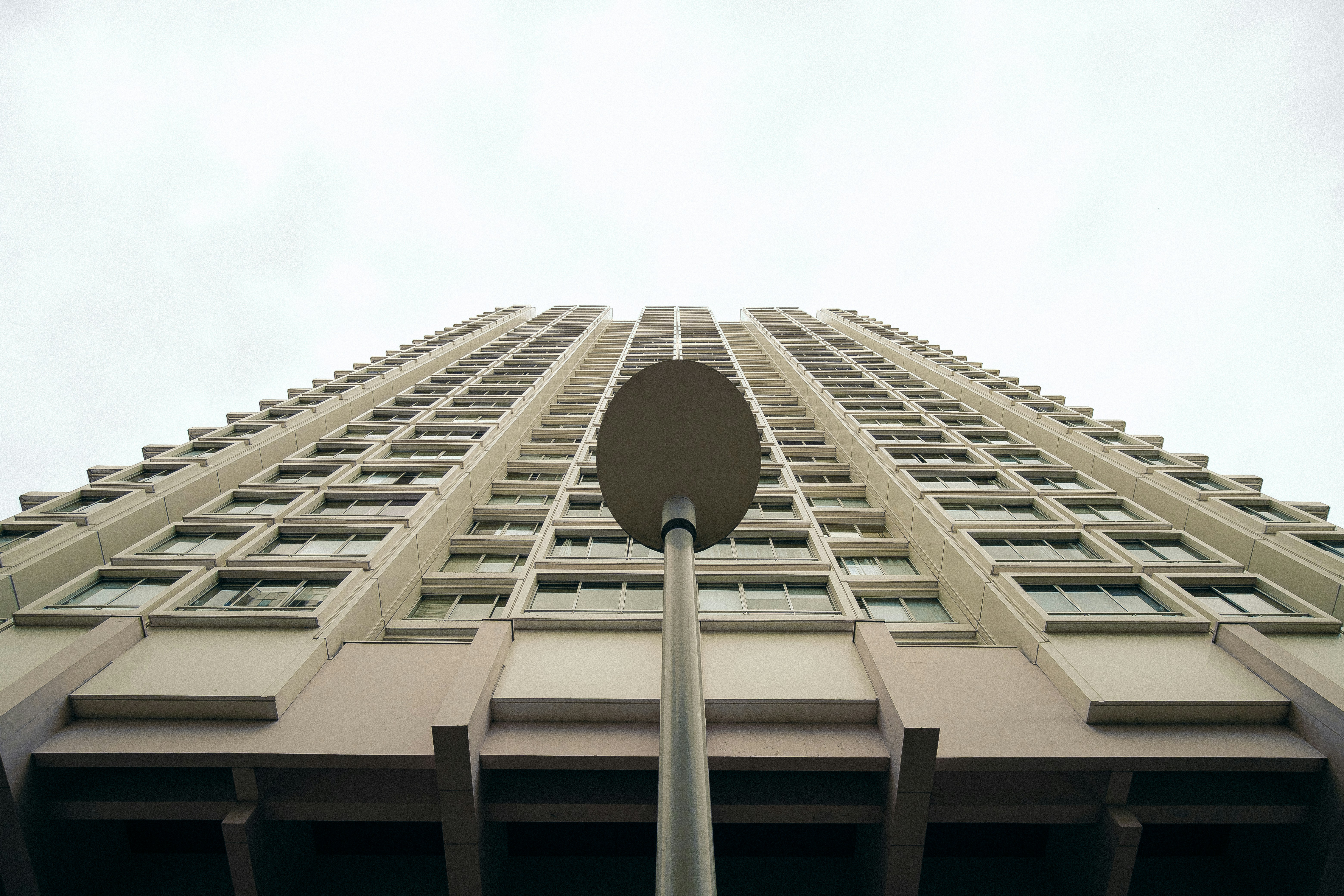 Looking up at a tall building with a lamp post.