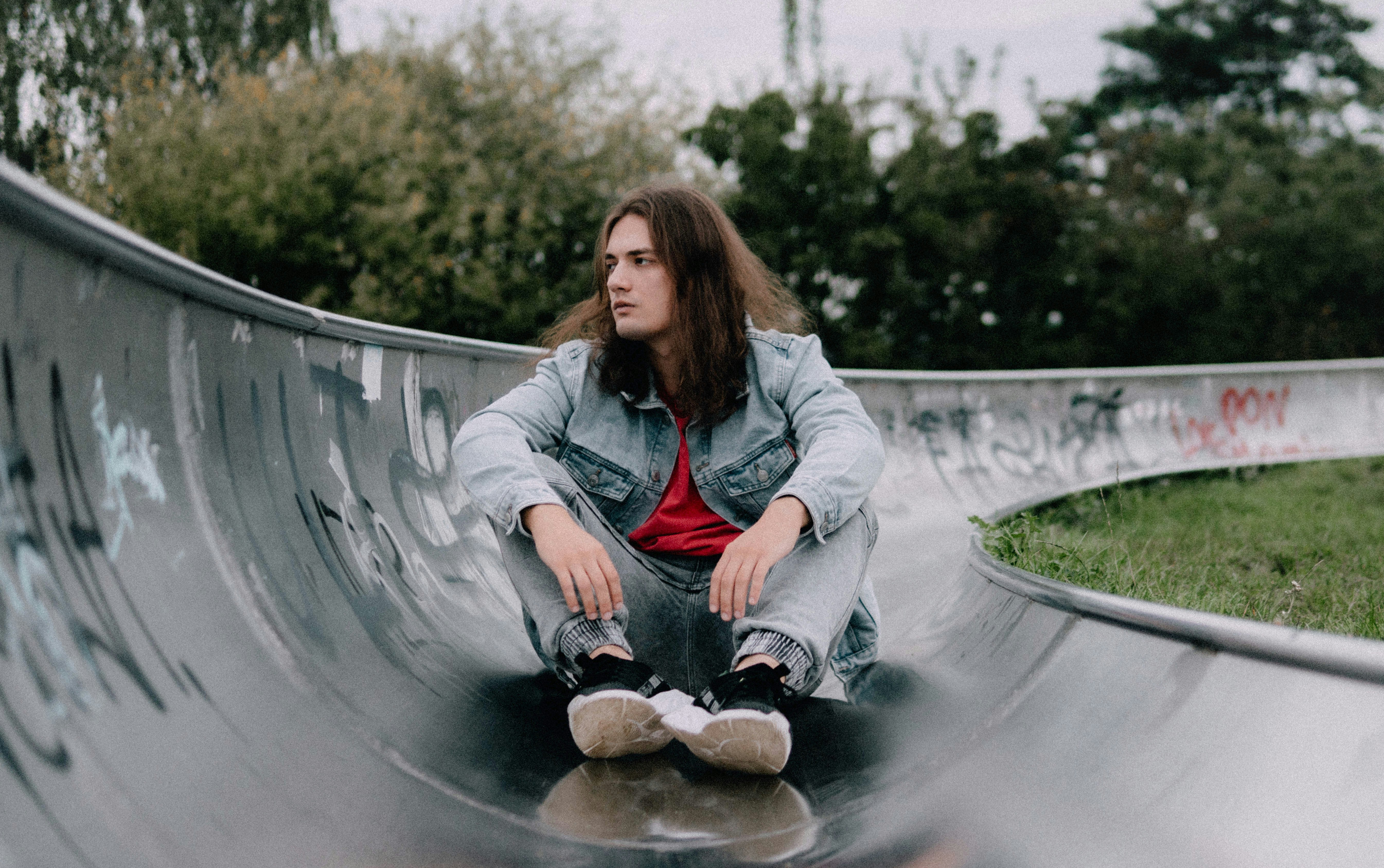 Young man sitting in a skatepark bowl