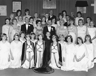 Group portrait of people in formal attire and costumes.