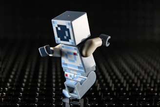 Lego figure with a white cube head and blue eyes.