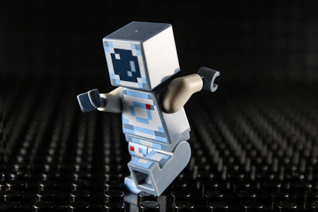 Lego figure with a white cube head and blue eyes.