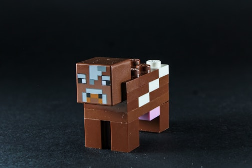 A brown minecraft cow toy on a black background