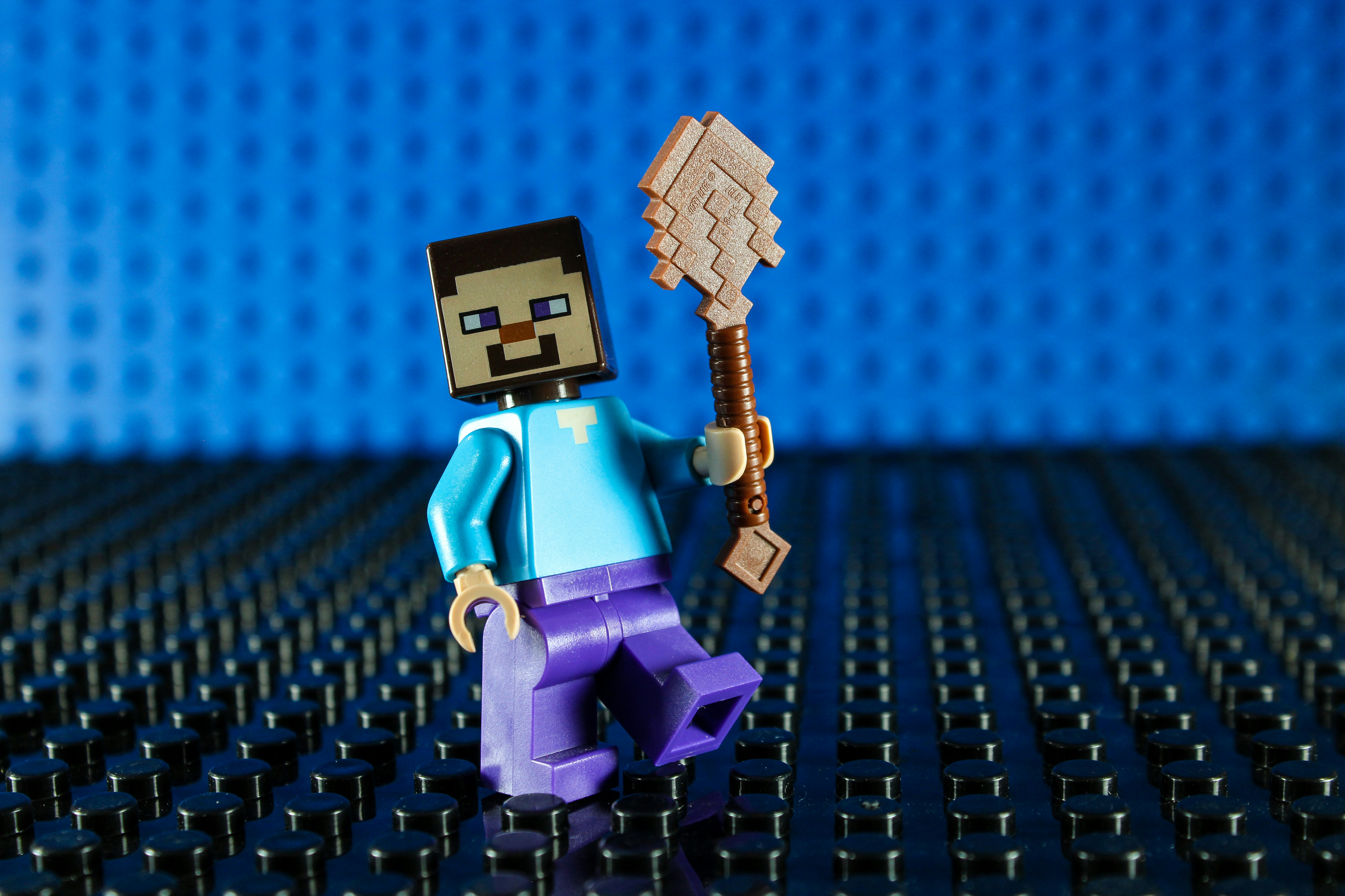 Minecraft character holding a shovel on a blue background