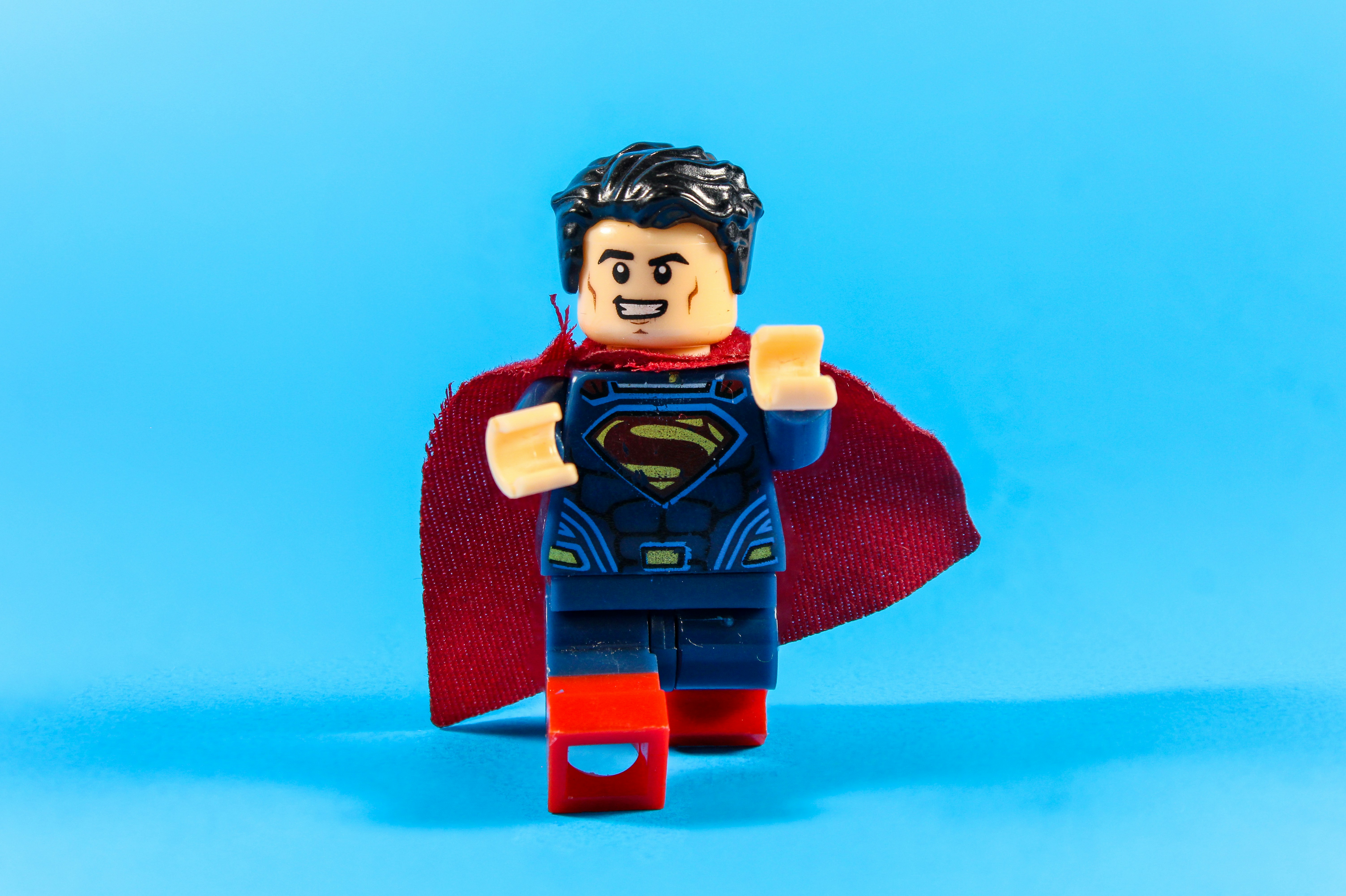 Figura lego di Superman con mantello rosso su sfondo blu