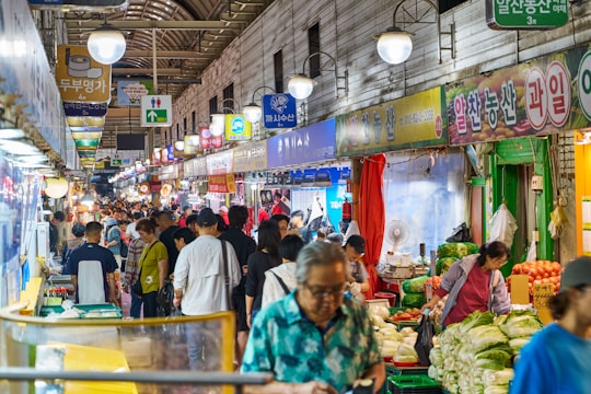 Crowded market with vendors selling produce and goods.