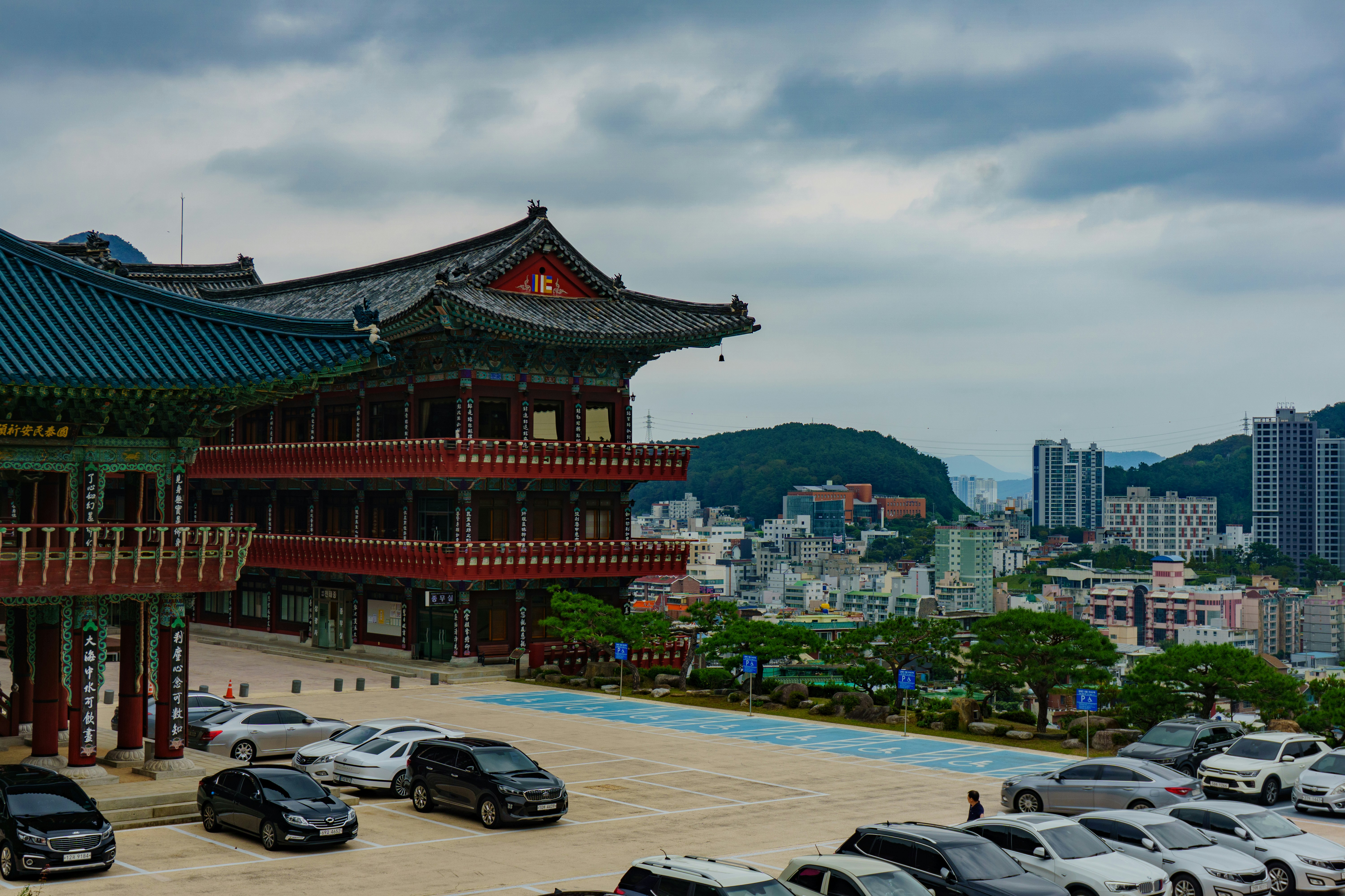 Traditional korean temple buildings with modern city in background.