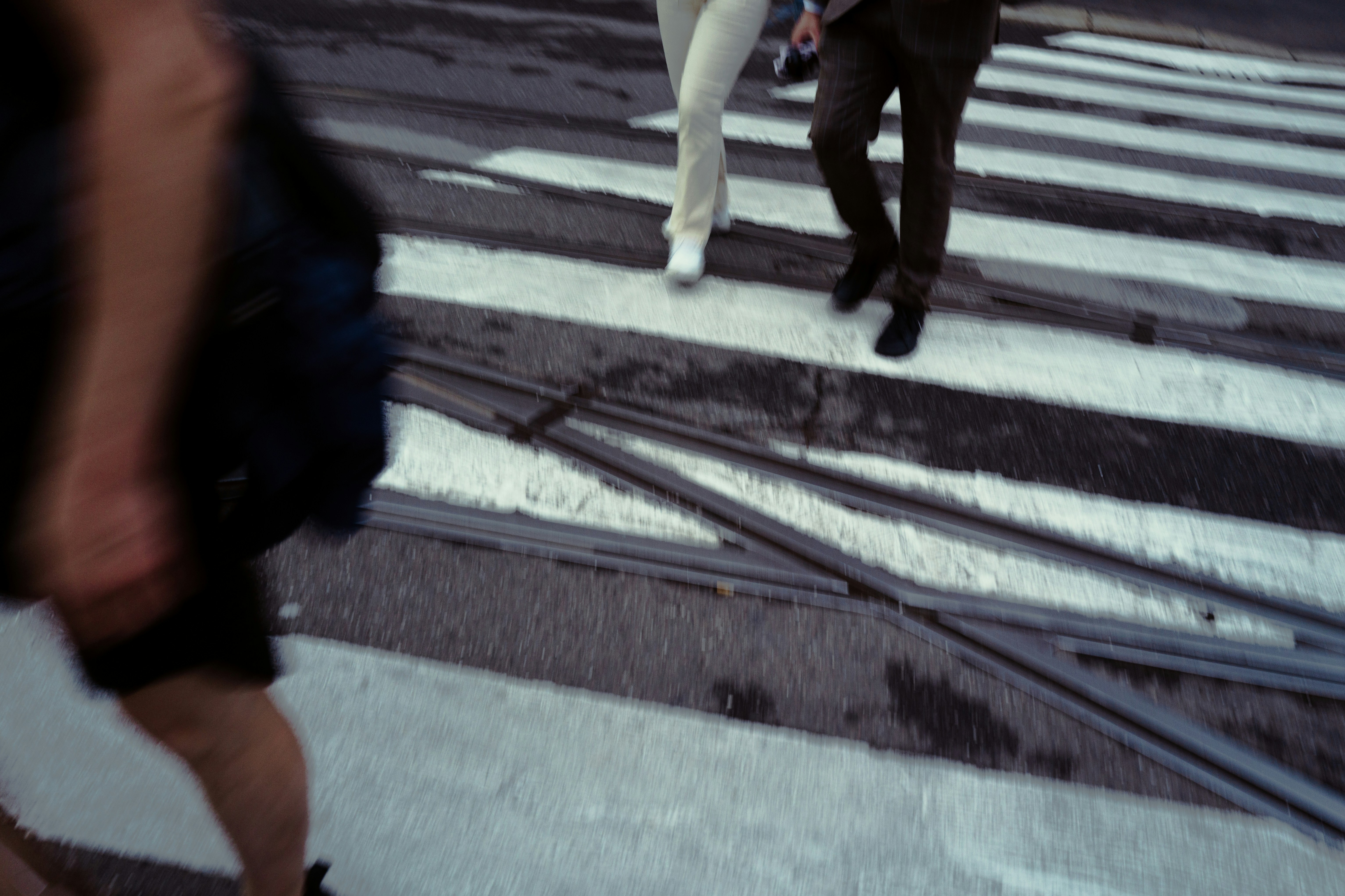 People crossing a street on a crosswalk.
