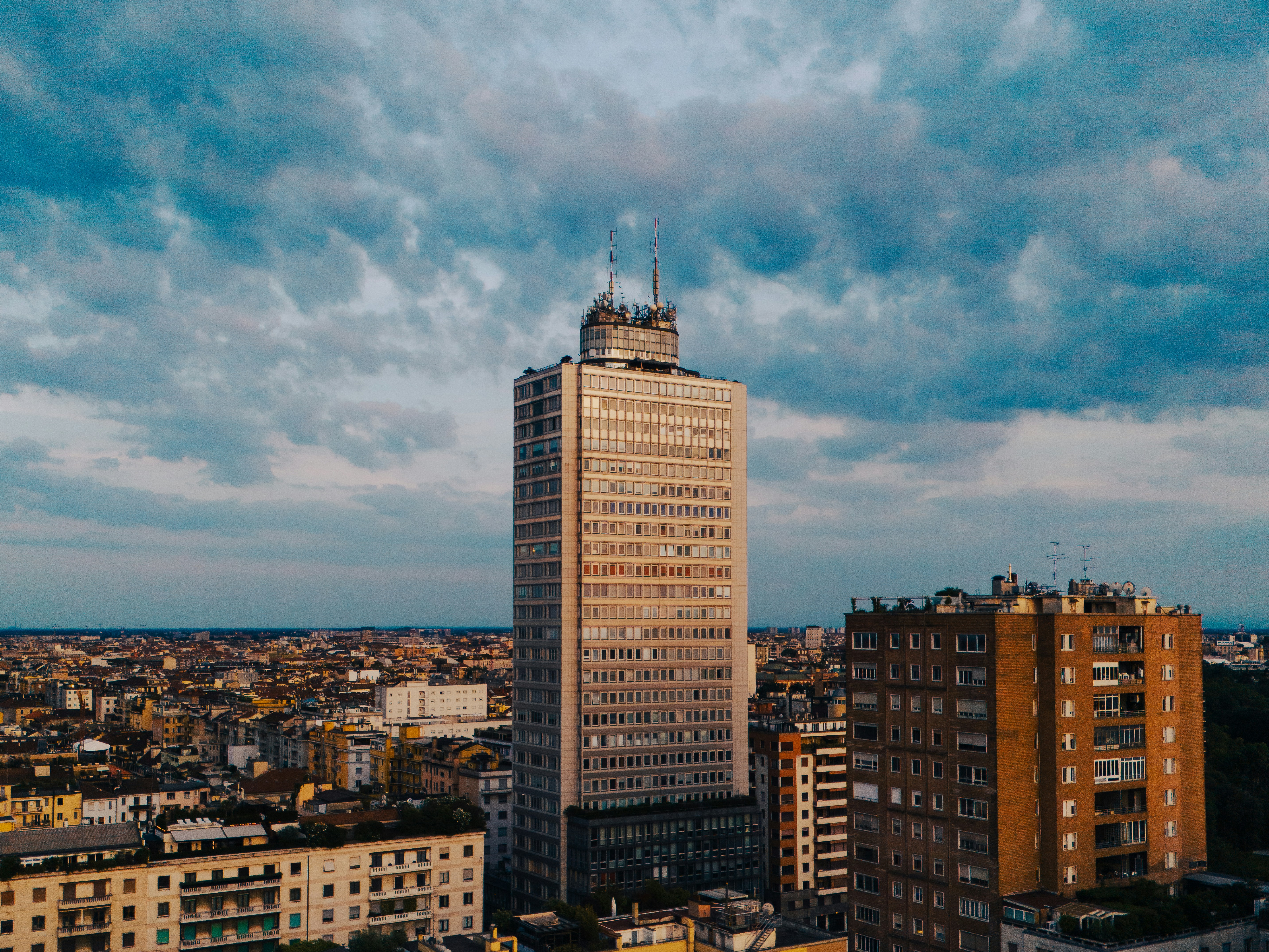 Tall skyscraper in a city under cloudy sky