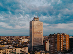Tall skyscraper in a city under cloudy sky