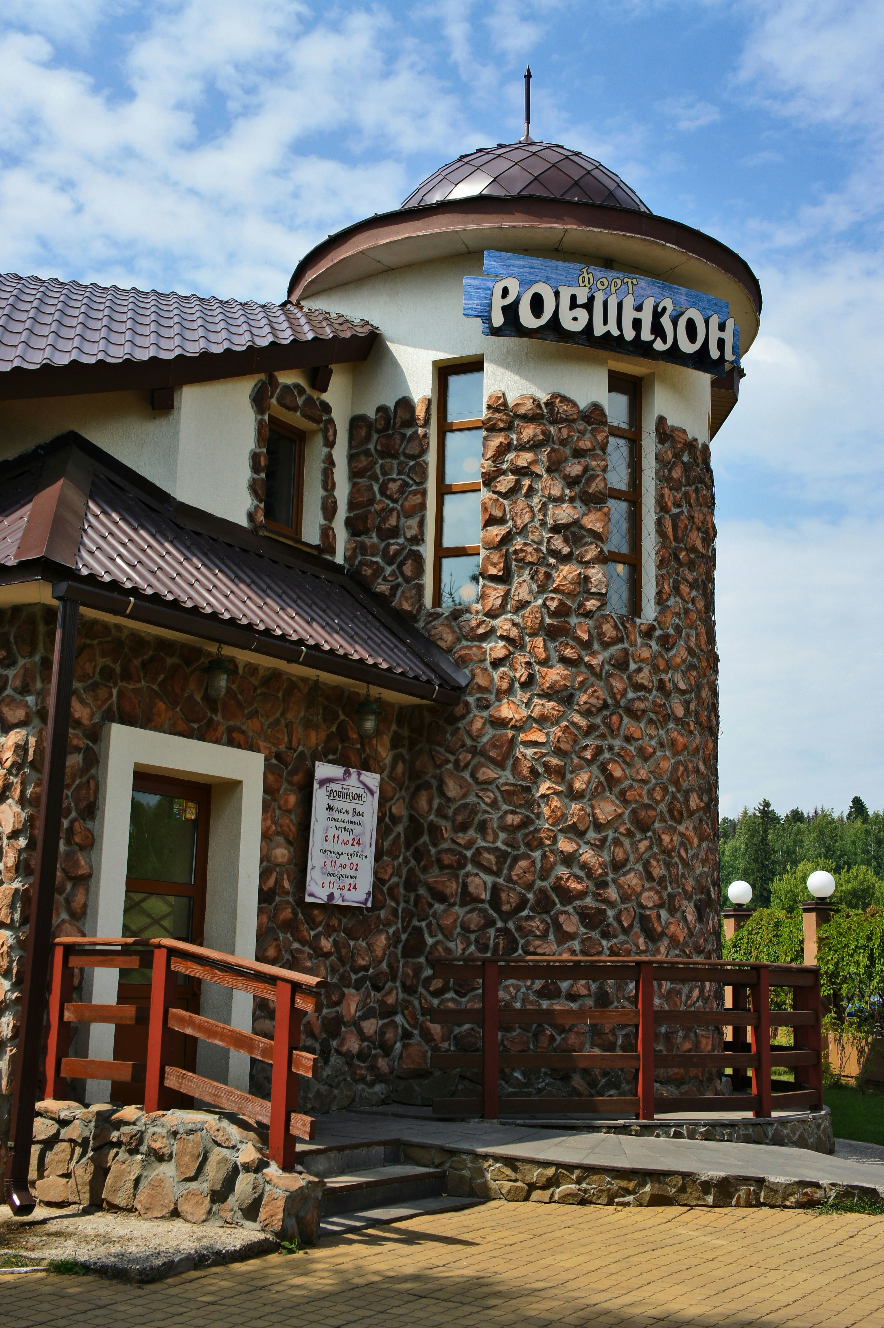 Building with stone facade and tower has sign