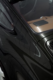 Close-up of a sleek black car interior and exterior.