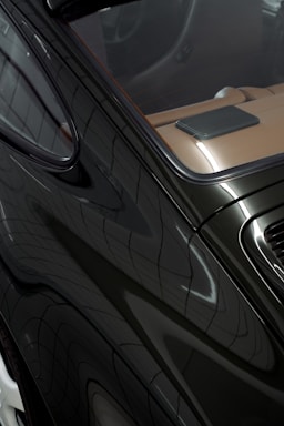 Close-up of a sleek black car interior and exterior.