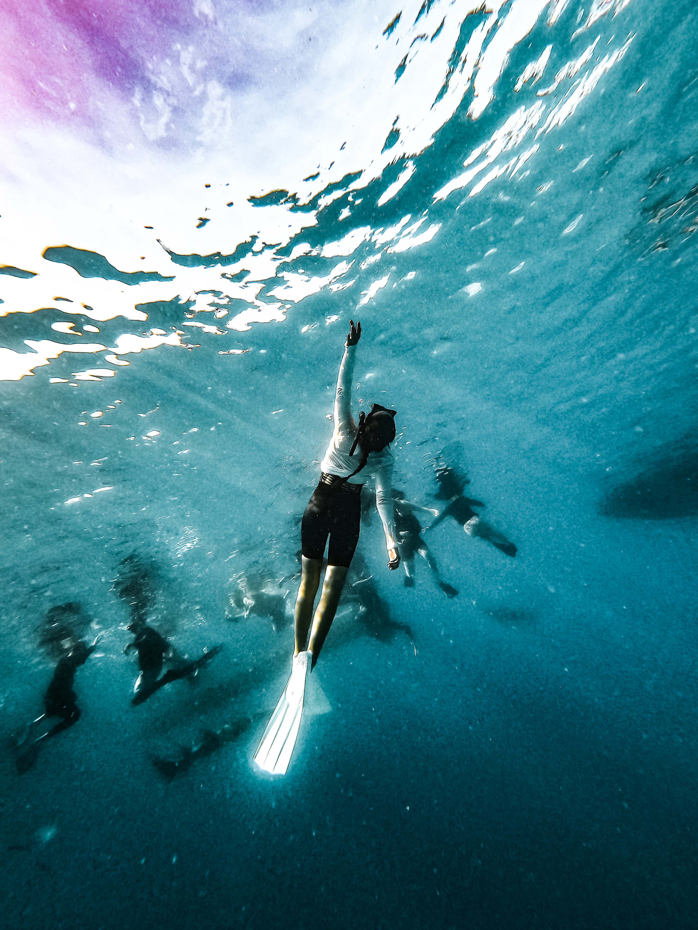 Snorkelers swimming together through clear blue ocean water